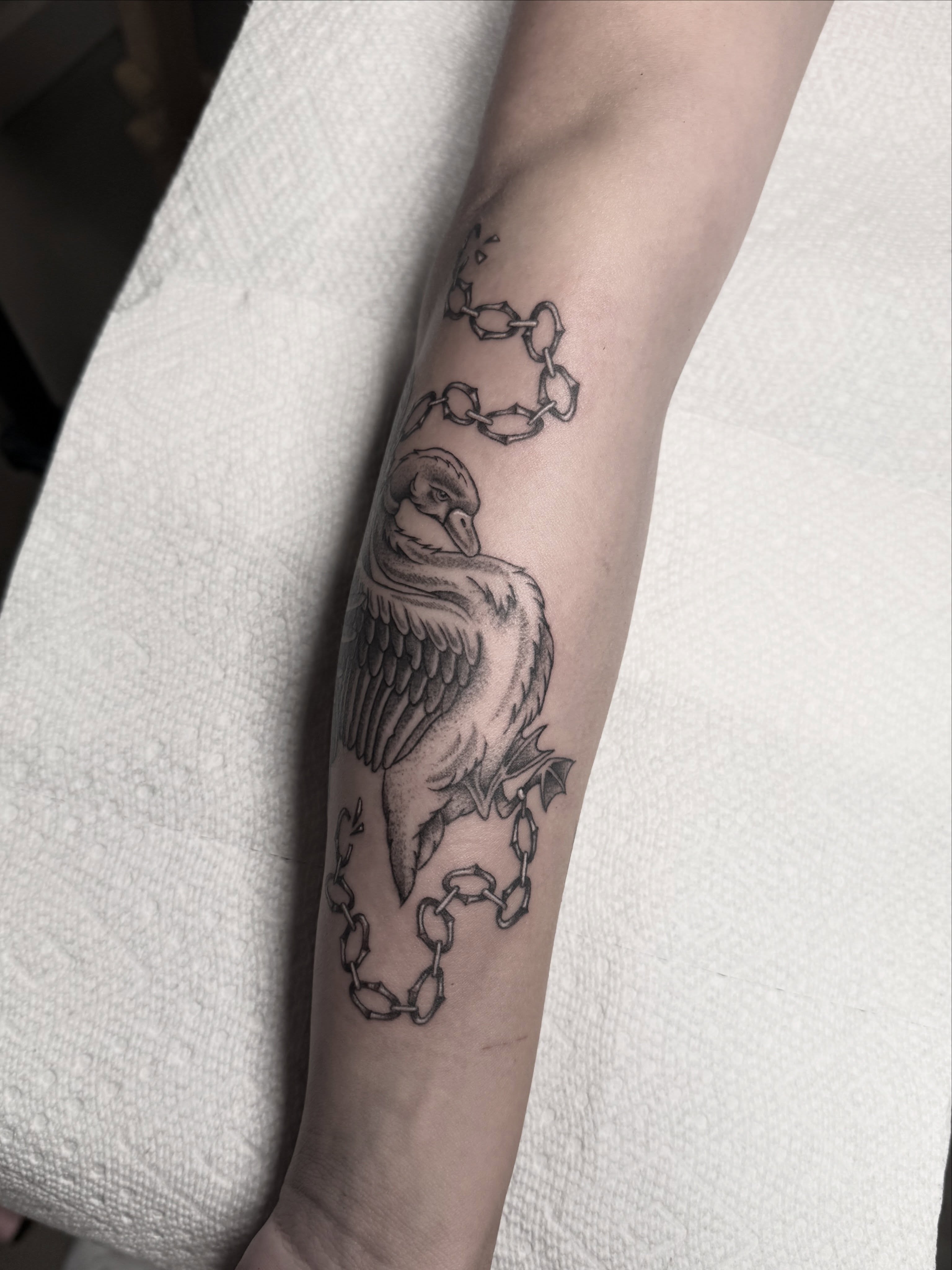 Goose with chains black and grey tattoo on the forearm by Mara Flores βπΛβ§