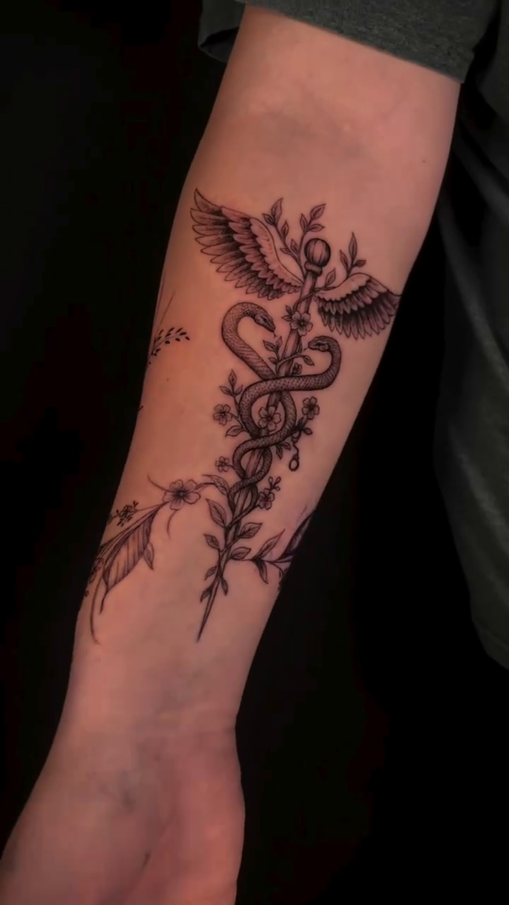 Caduceus with wings and floral elements ornamental tattoo by Jessica Sheahan