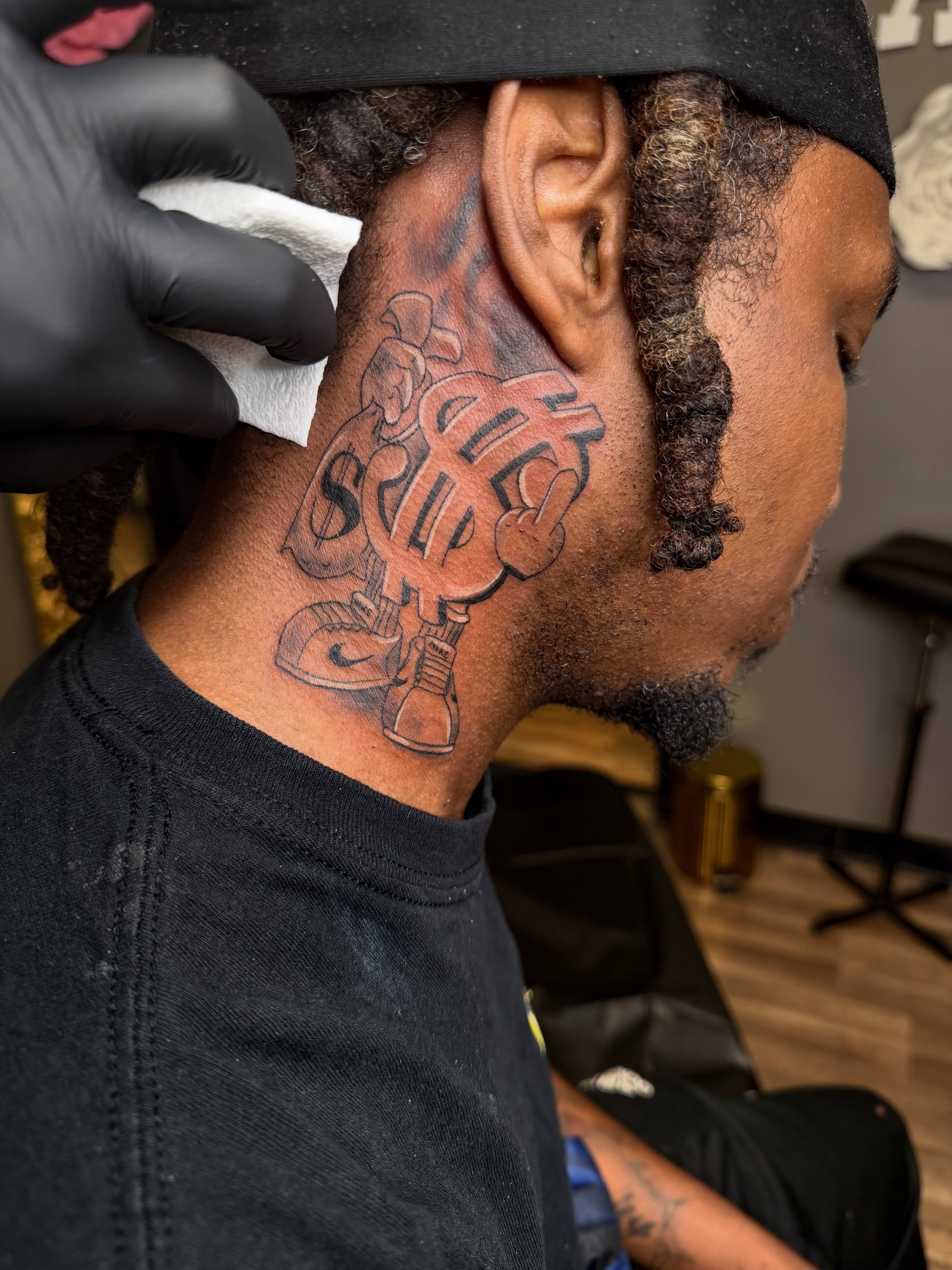 Money bag with dollar sign black and grey tattoo on the neck by Rain David