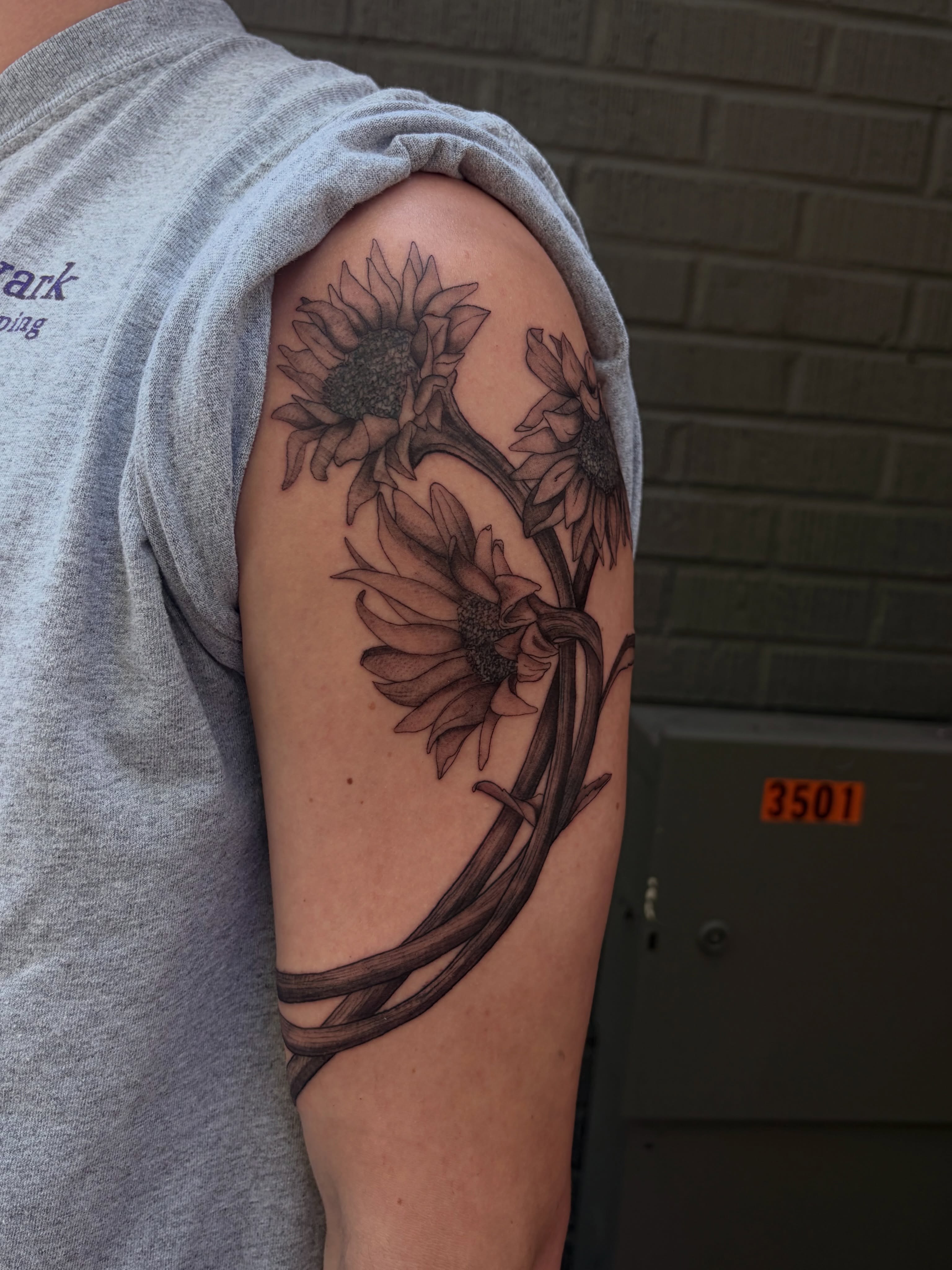 Sunflowers black and grey tattoo on the forearm by father