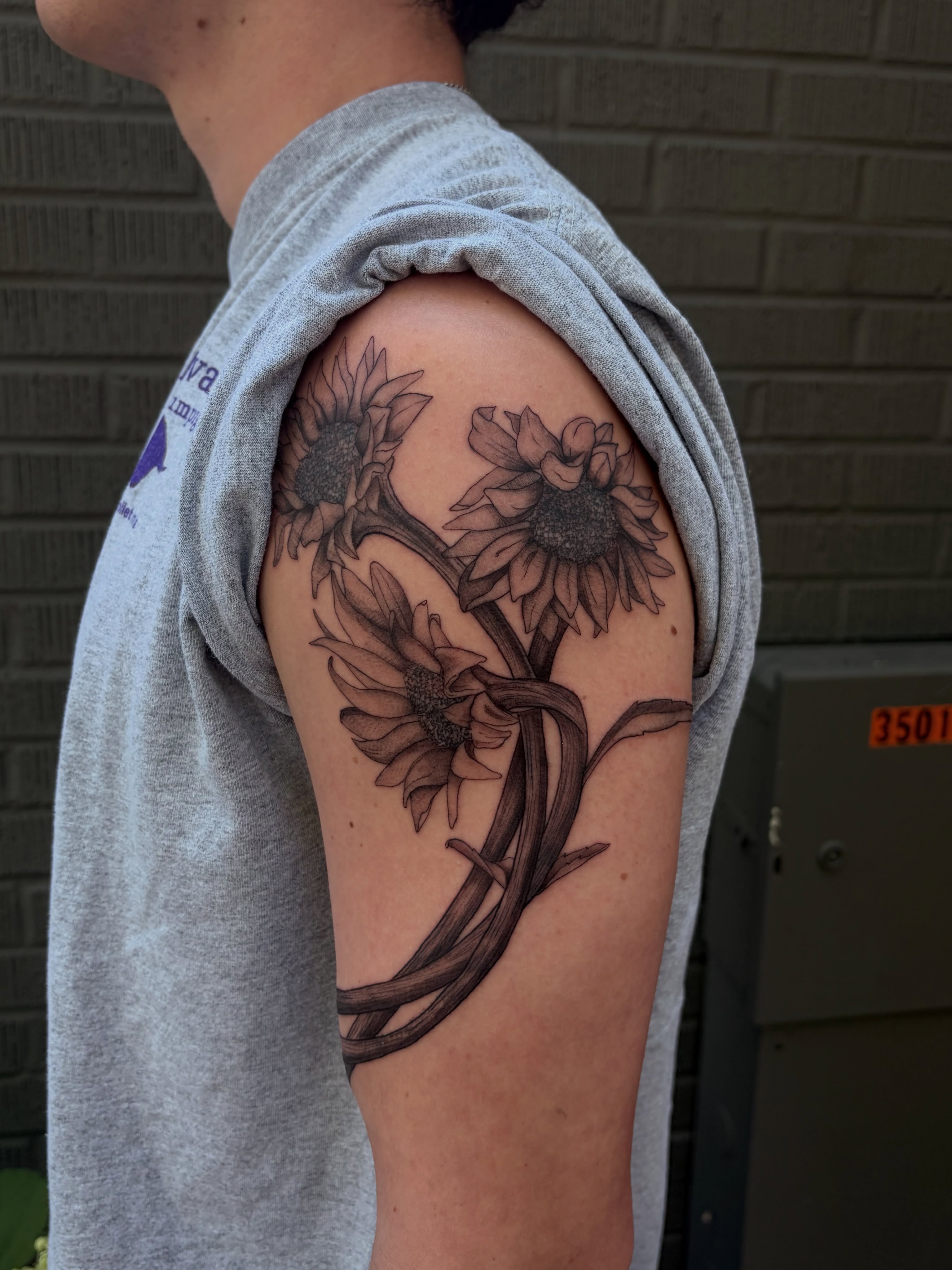 Sunflowers black and grey tattoo on the shoulder by father