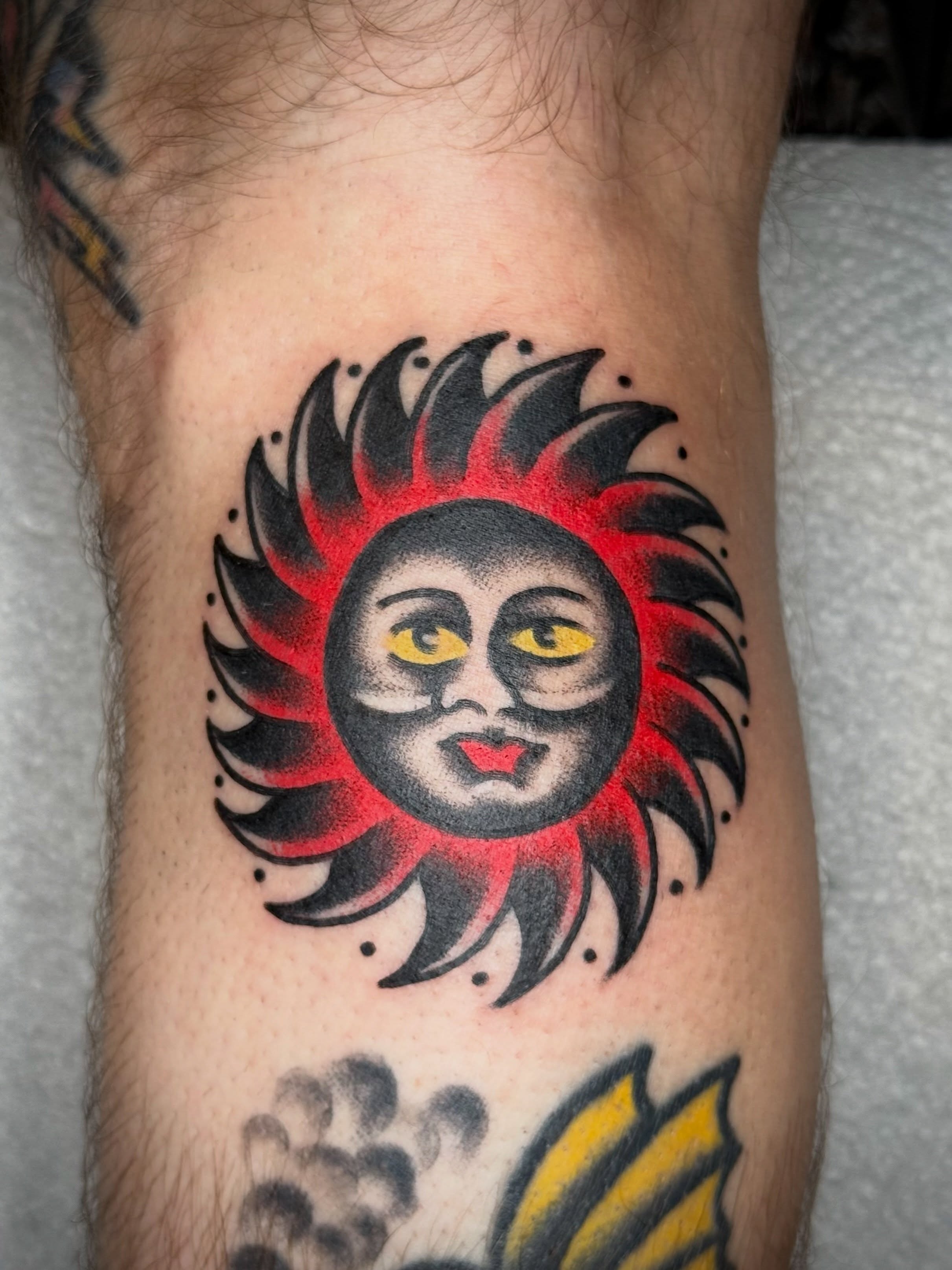 Sun face American traditional tattoo on the forearm by Maximilian Harrison