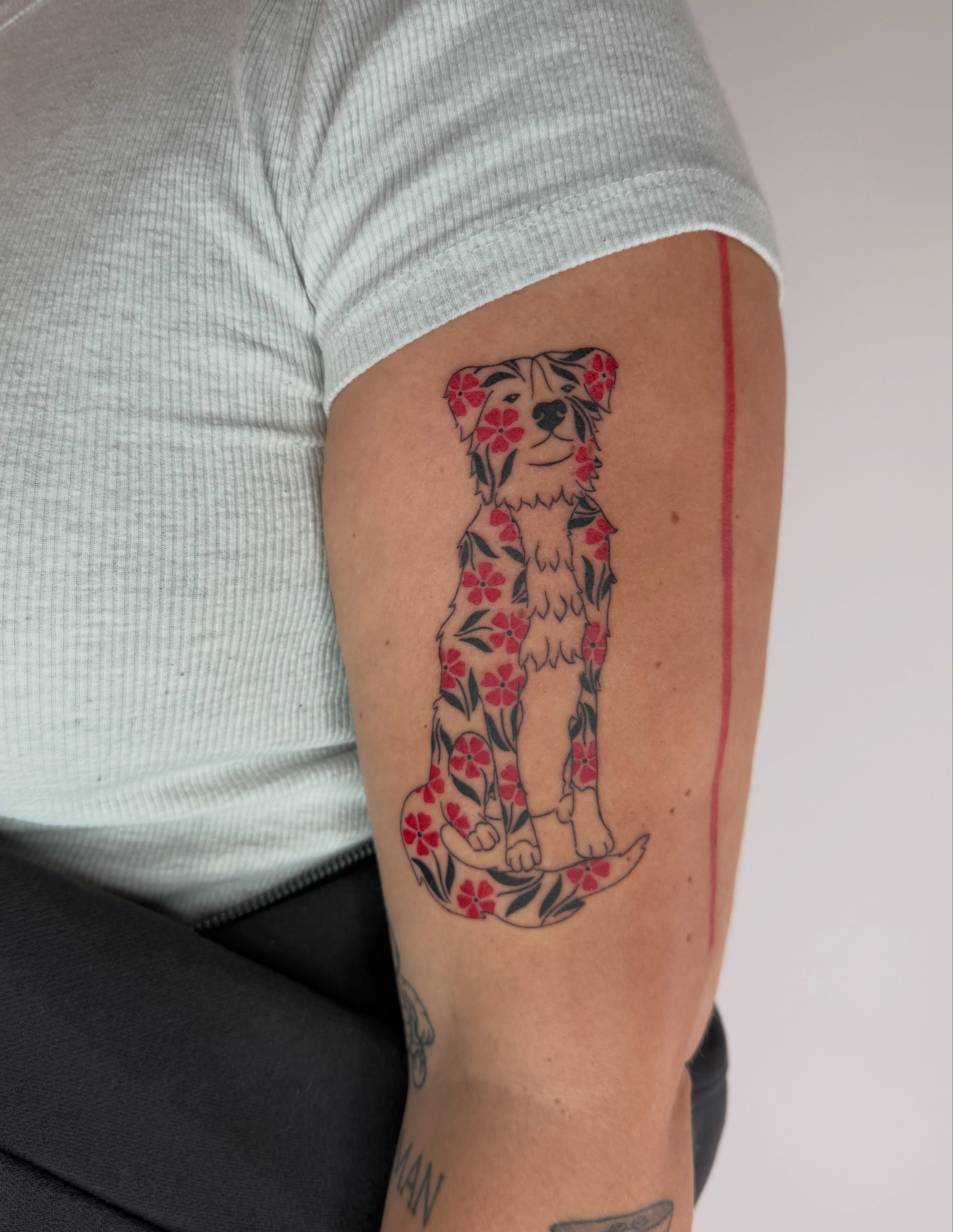 Dog with floral pattern new school tattoo on the forearm by Leah Ramos