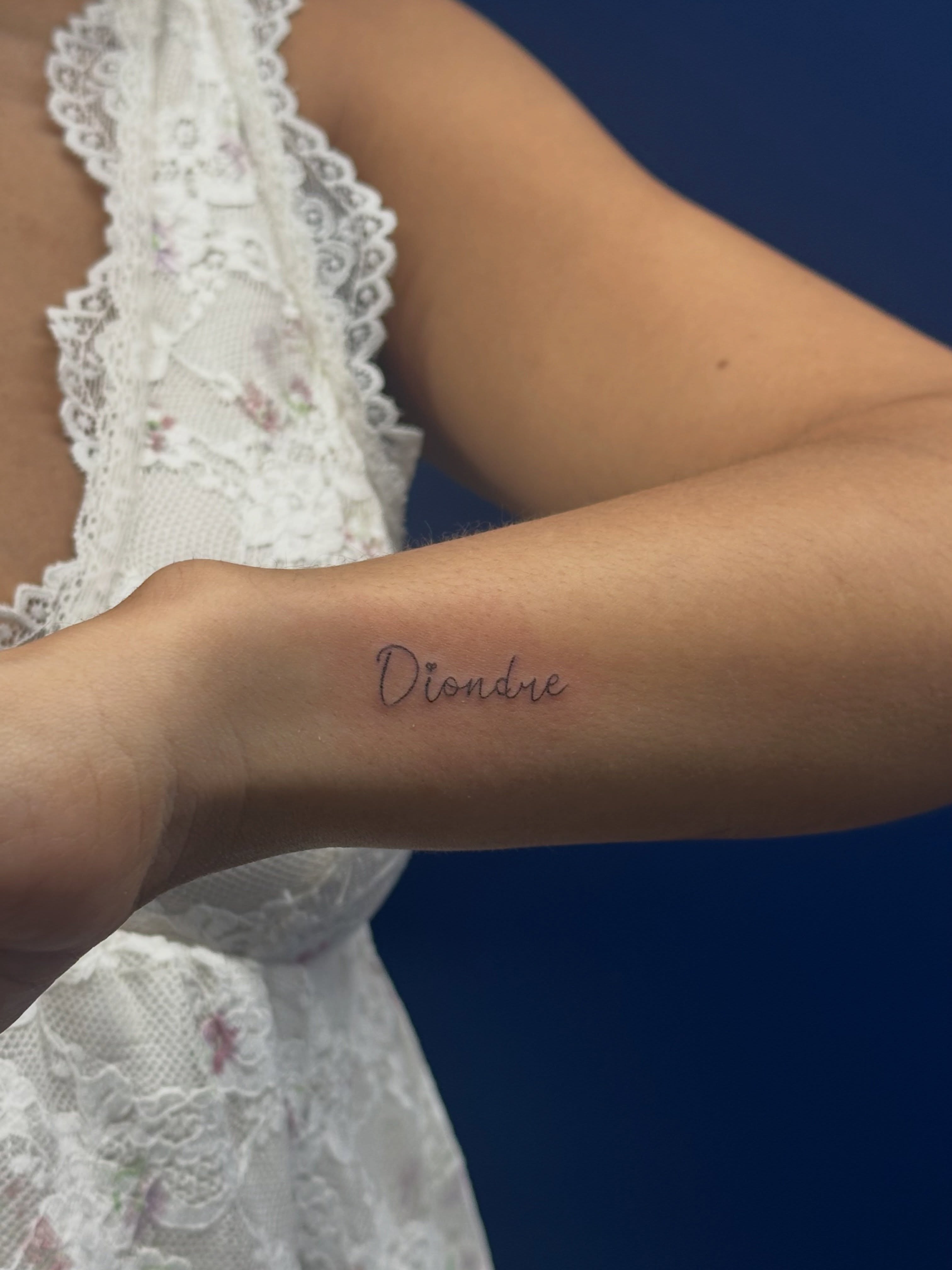 Diondre lettering script tattoo on the forearm by Tattoo Takayo