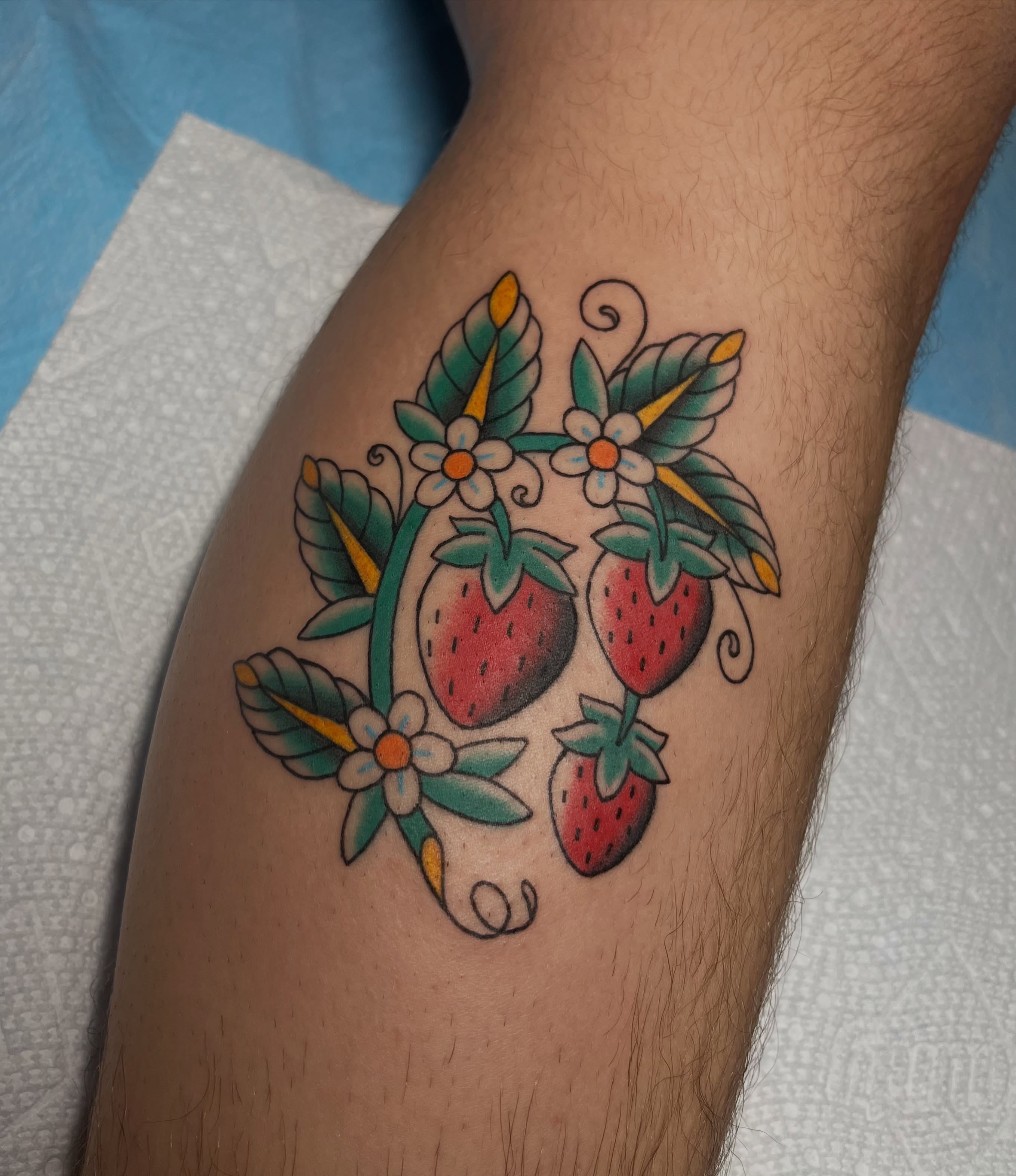 Strawberries and flowers American traditional tattoo on the thigh by Taylor Newton
