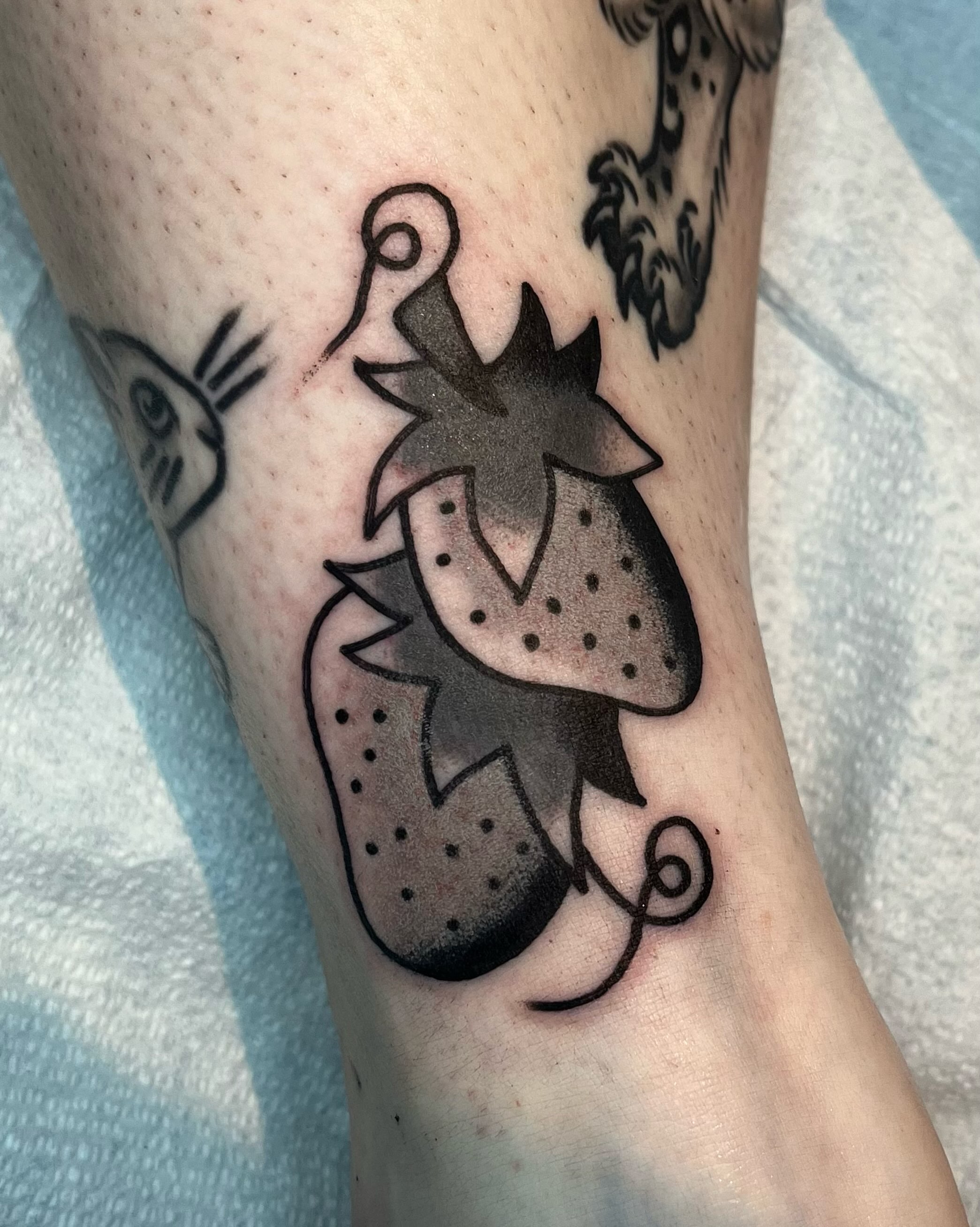 Strawberry dotwork tattoo on the forearm by Em Adkins