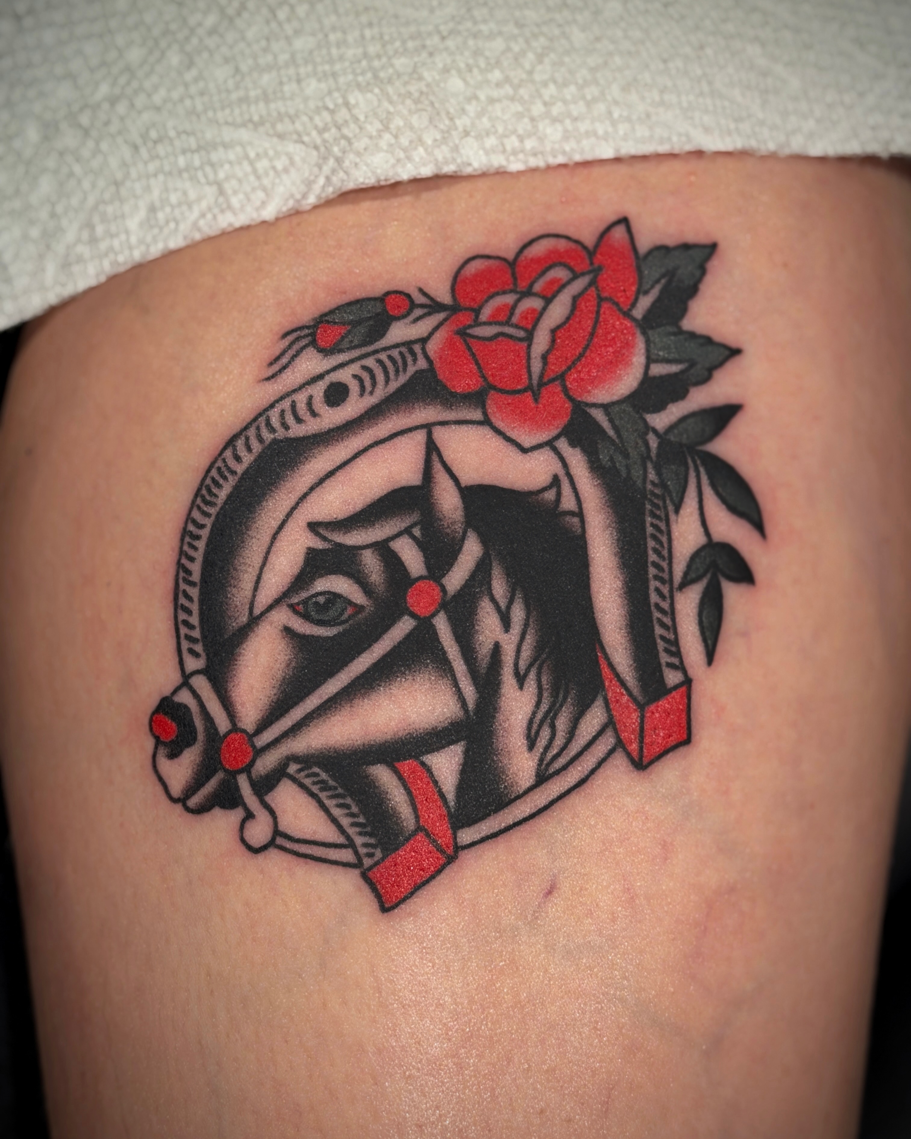 Horse head with roses American traditional tattoo on the thigh by Diego Treviño