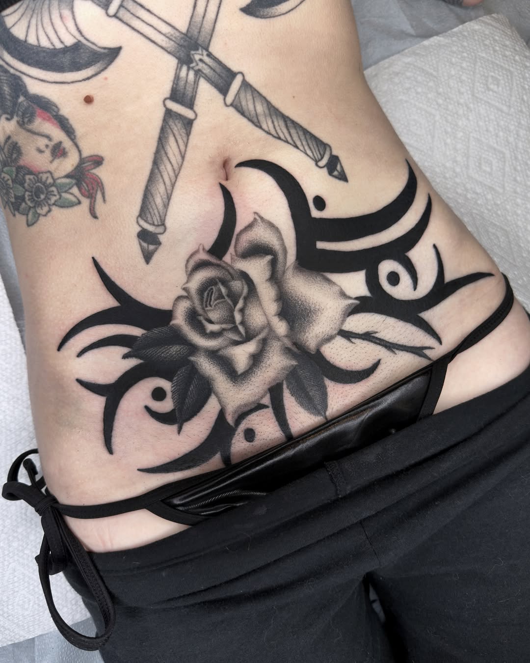 Rose and eyes American traditional tattoo on the ribs by Diego Treviño