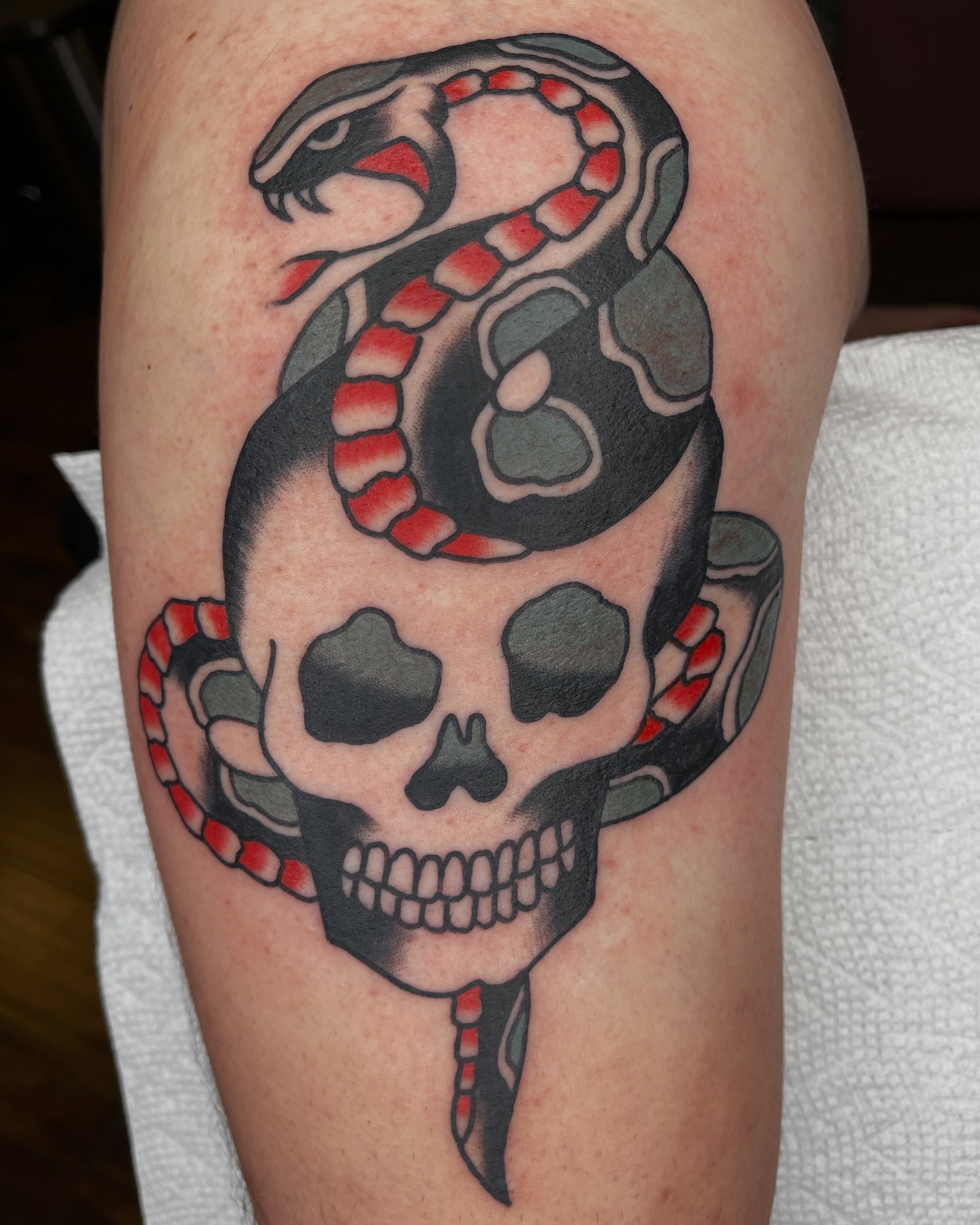 Snake and skull American traditional tattoo on the thigh by Diego Treviño