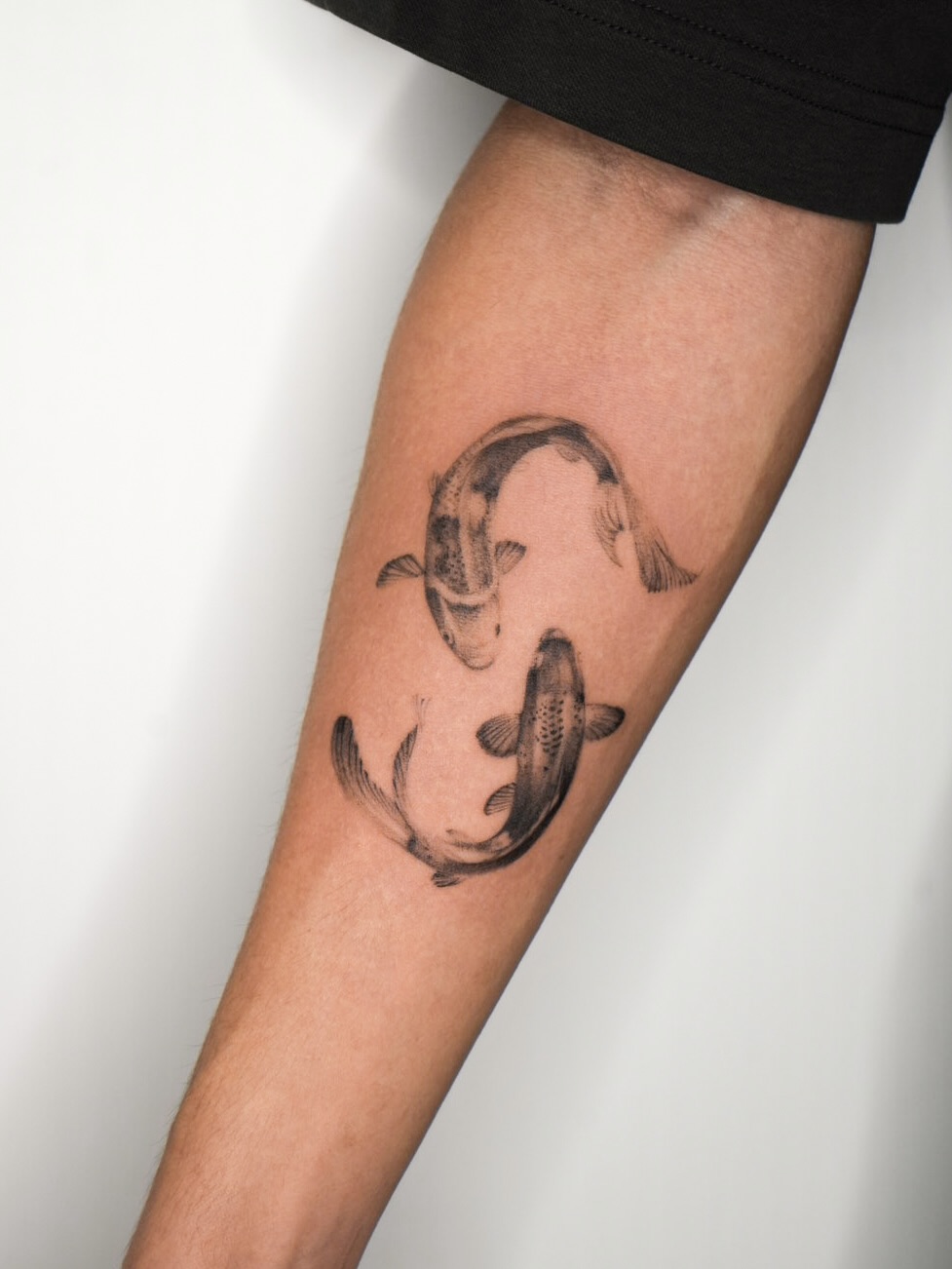 Koi fish black and grey tattoo on the forearm by Blackwork & microrealism tattoos