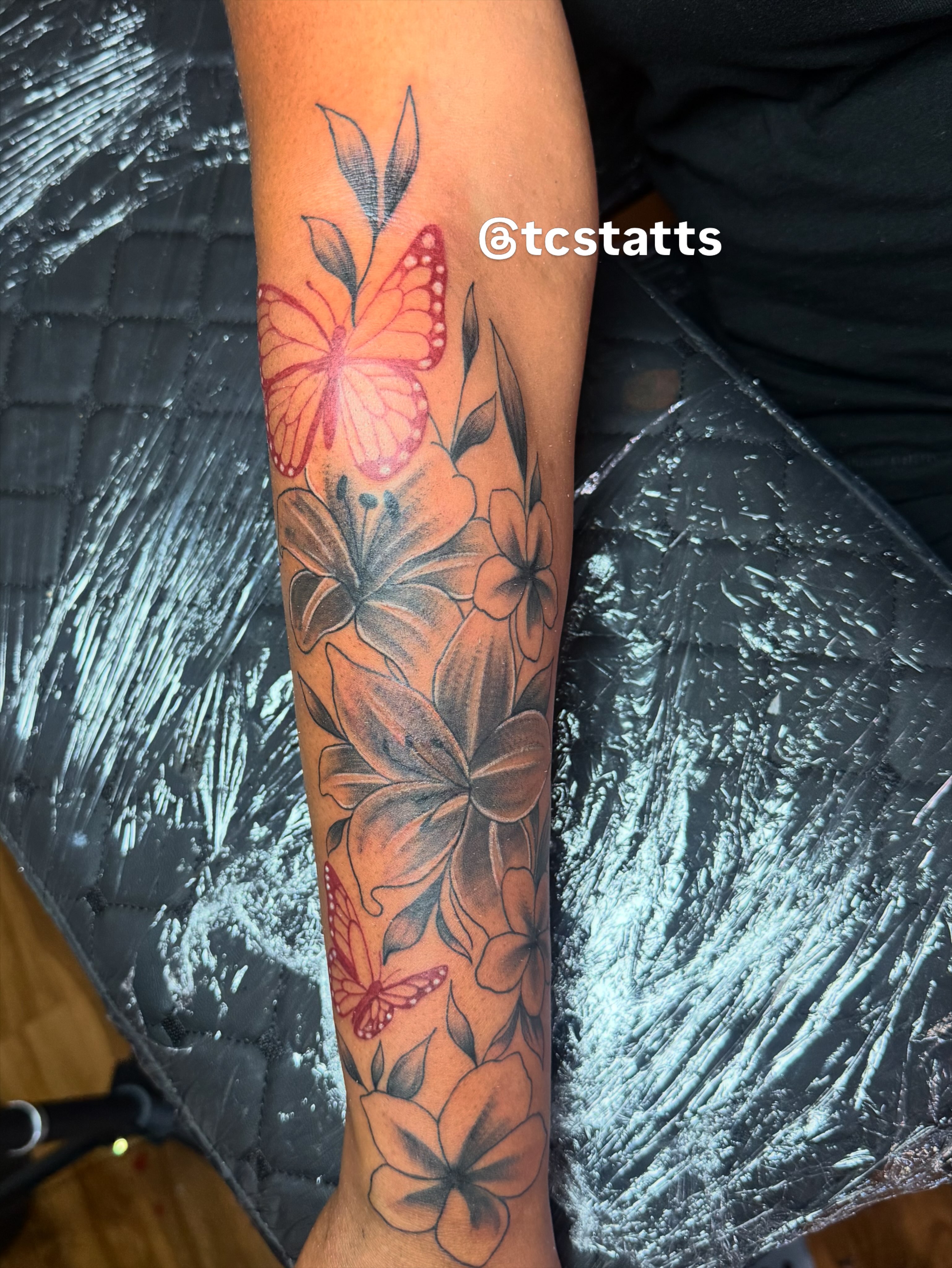 Butterfly and flowers realism tattoo on the forearm by Tcstatts