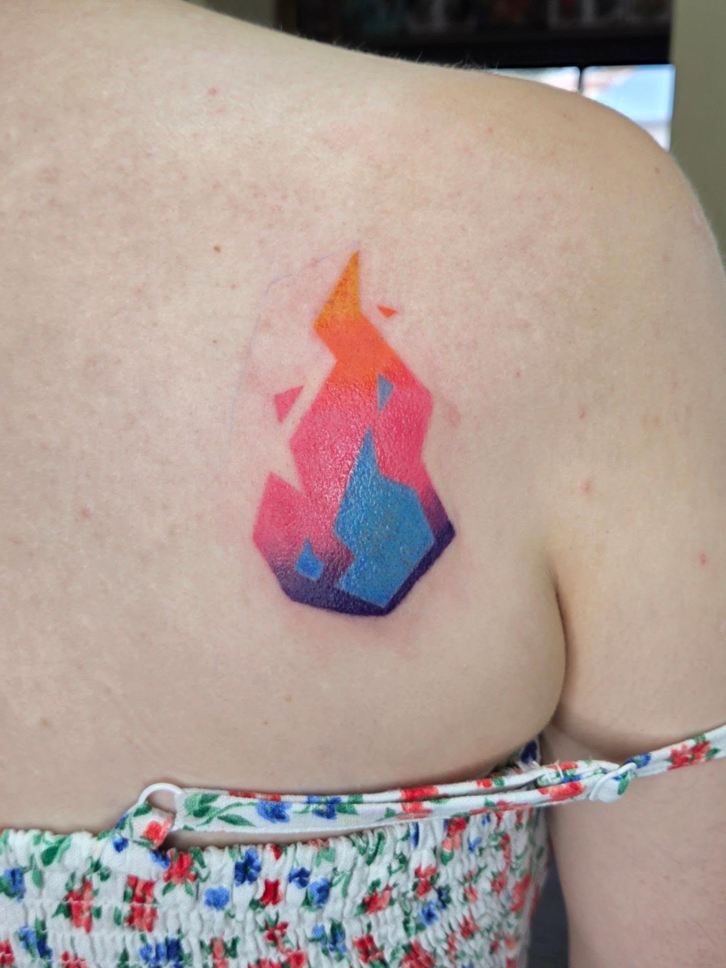 Geometric flame geometric tattoo on the shoulder by Jessica Duggan