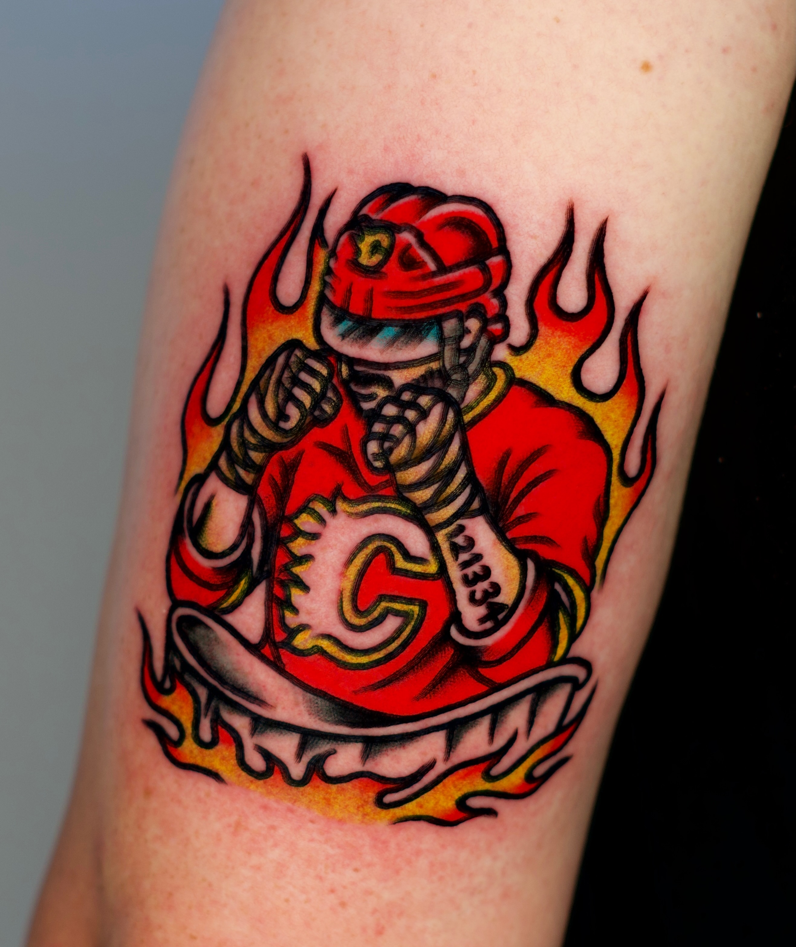 Firefighter helmet and jersey American traditional tattoo on the forearm by Tattooer Sancho 🇰🇷🇨🇦