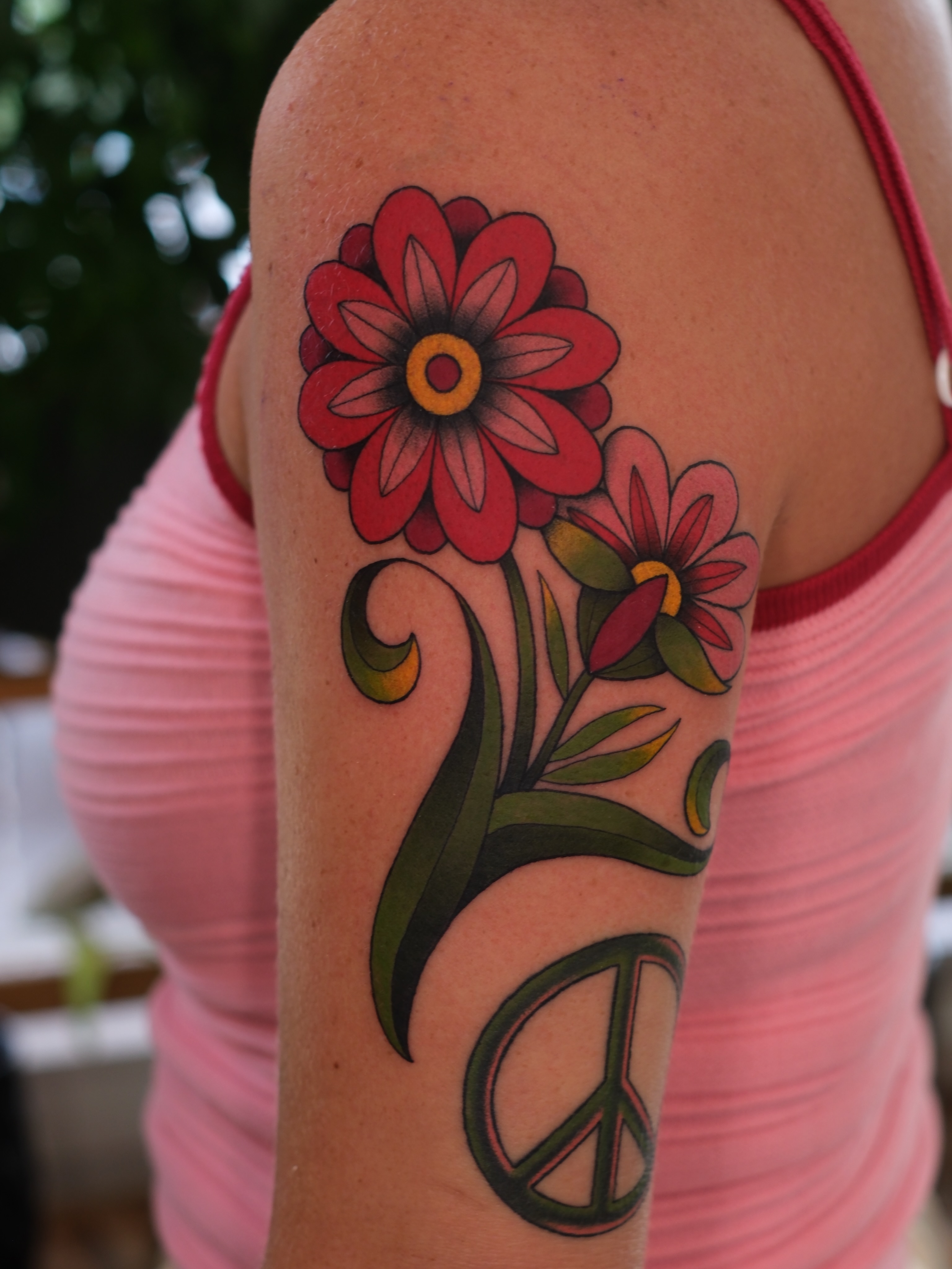 Flowers and peace sign American traditional tattoo on the upper arm by Mallory Murphy, Denton, Texas