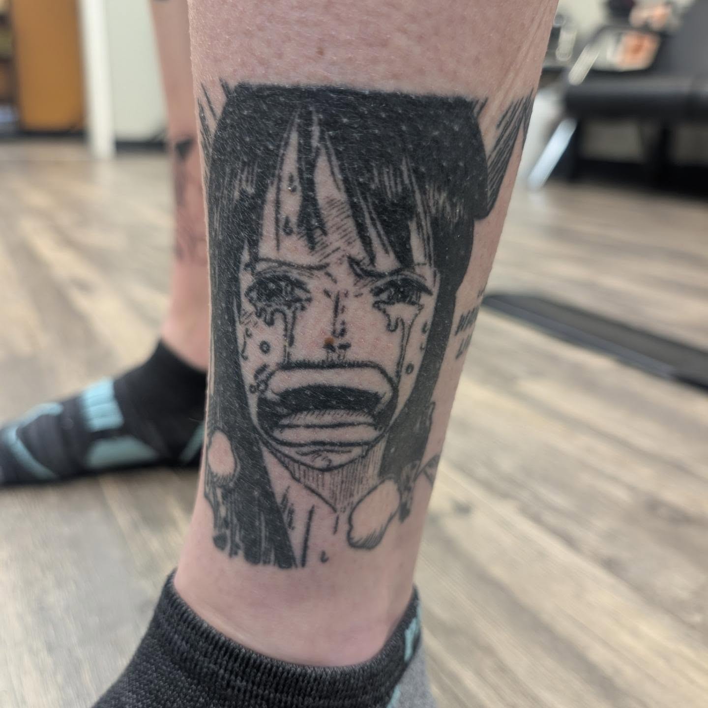 Crying face black and grey tattoo on the forearm by Talia Zula, Loveland, Ohio