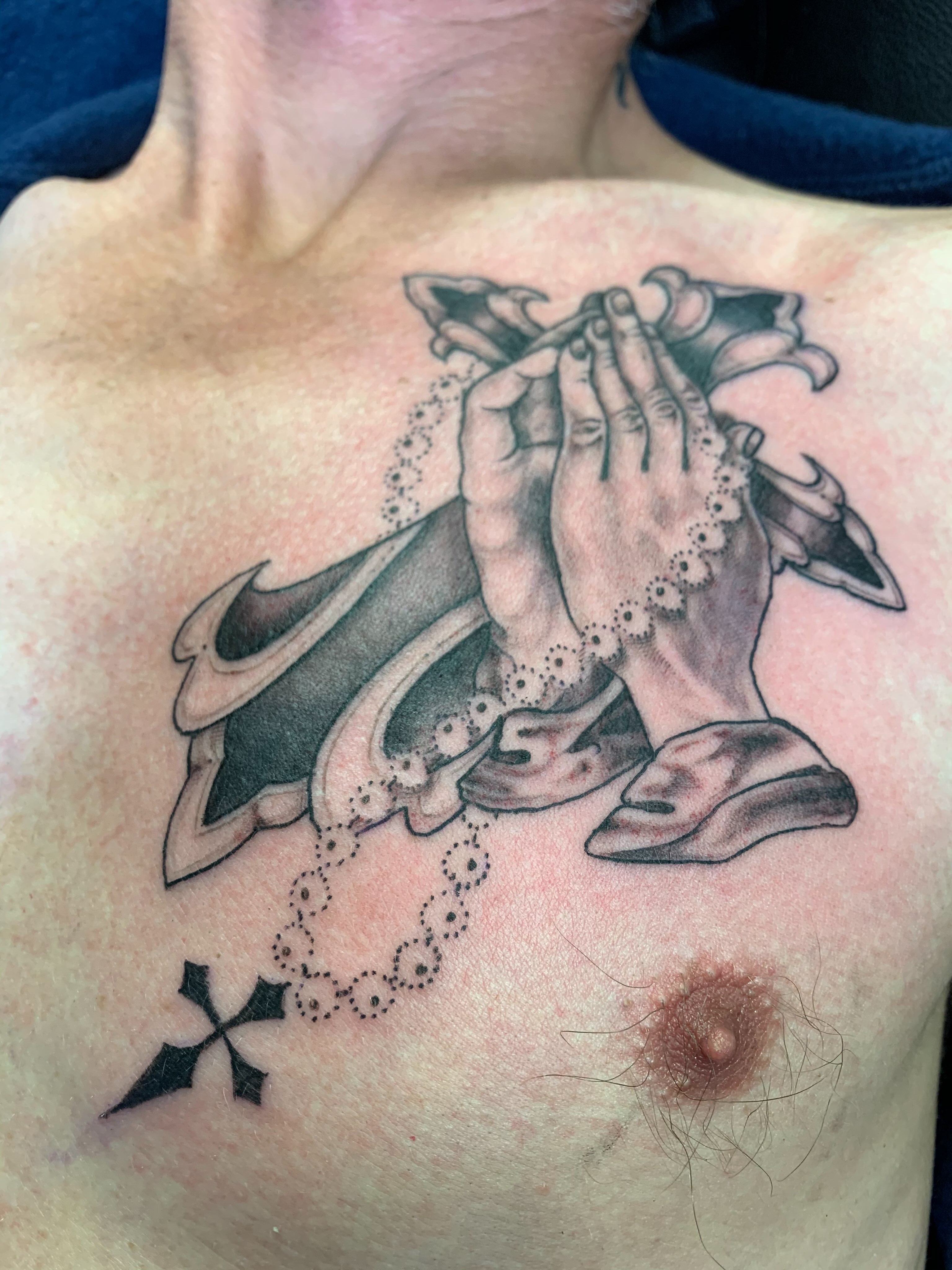 Praying hands dotwork tattoo on the chest by El Kapitan