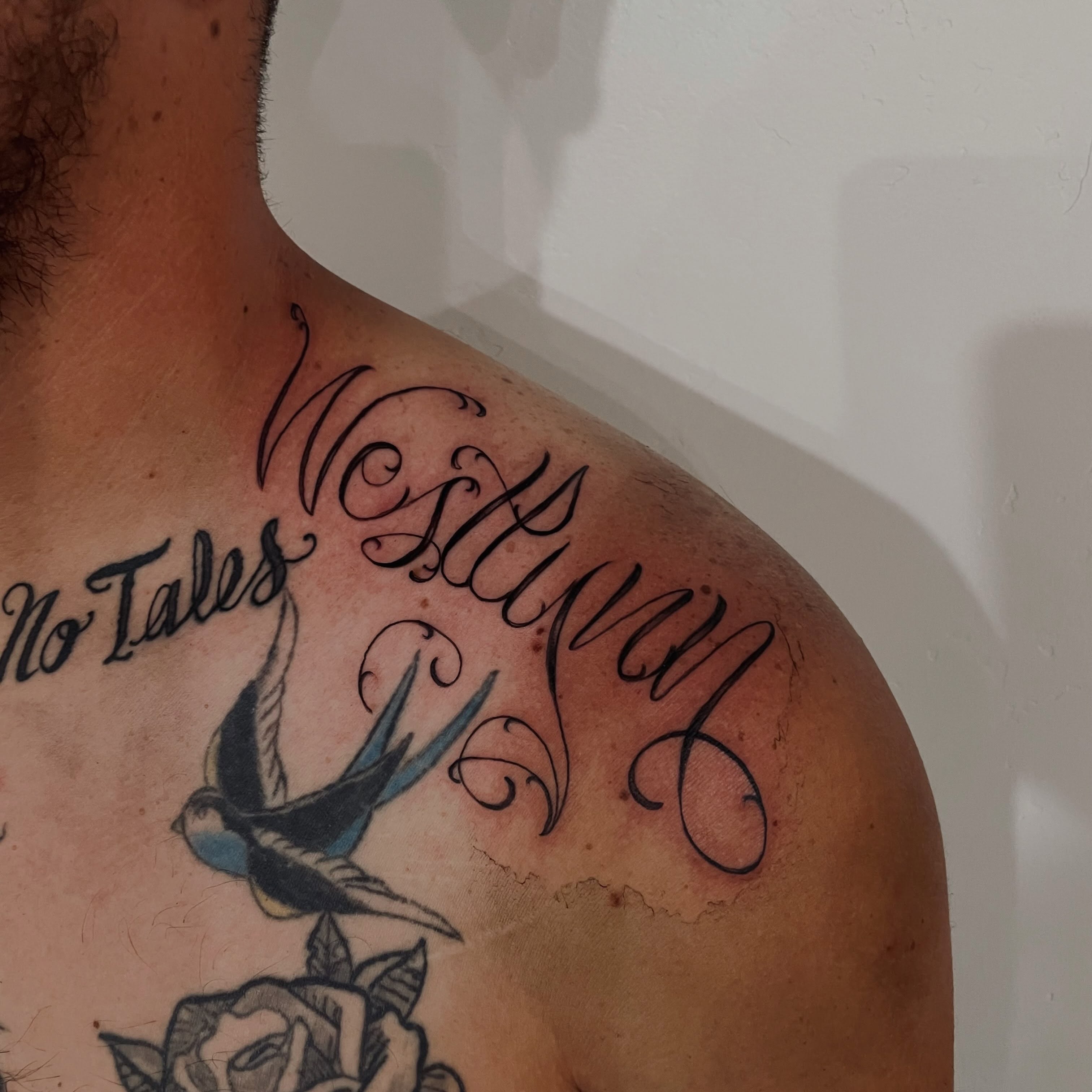 Swallow and cursive text black and grey tattoo on the shoulder by Christien Xavier Alba, Salt Lake City, Utah