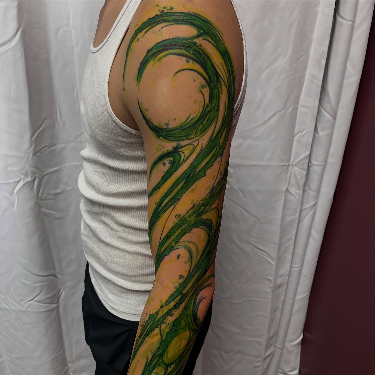 Swirls watercolor tattoo on the upper arm by Cameron Jenkins