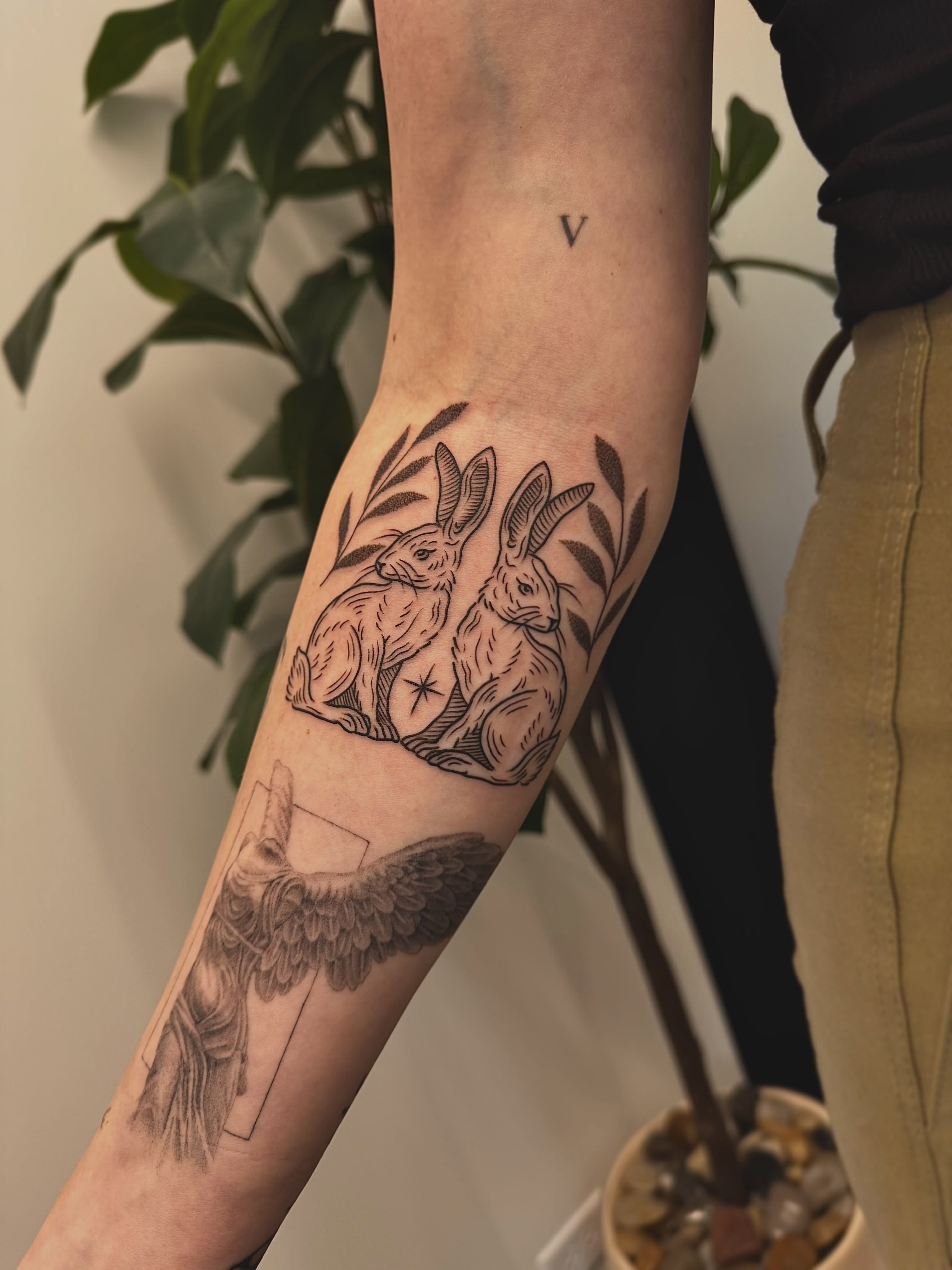 Rabbits black and grey tattoo on the forearm by Stefany