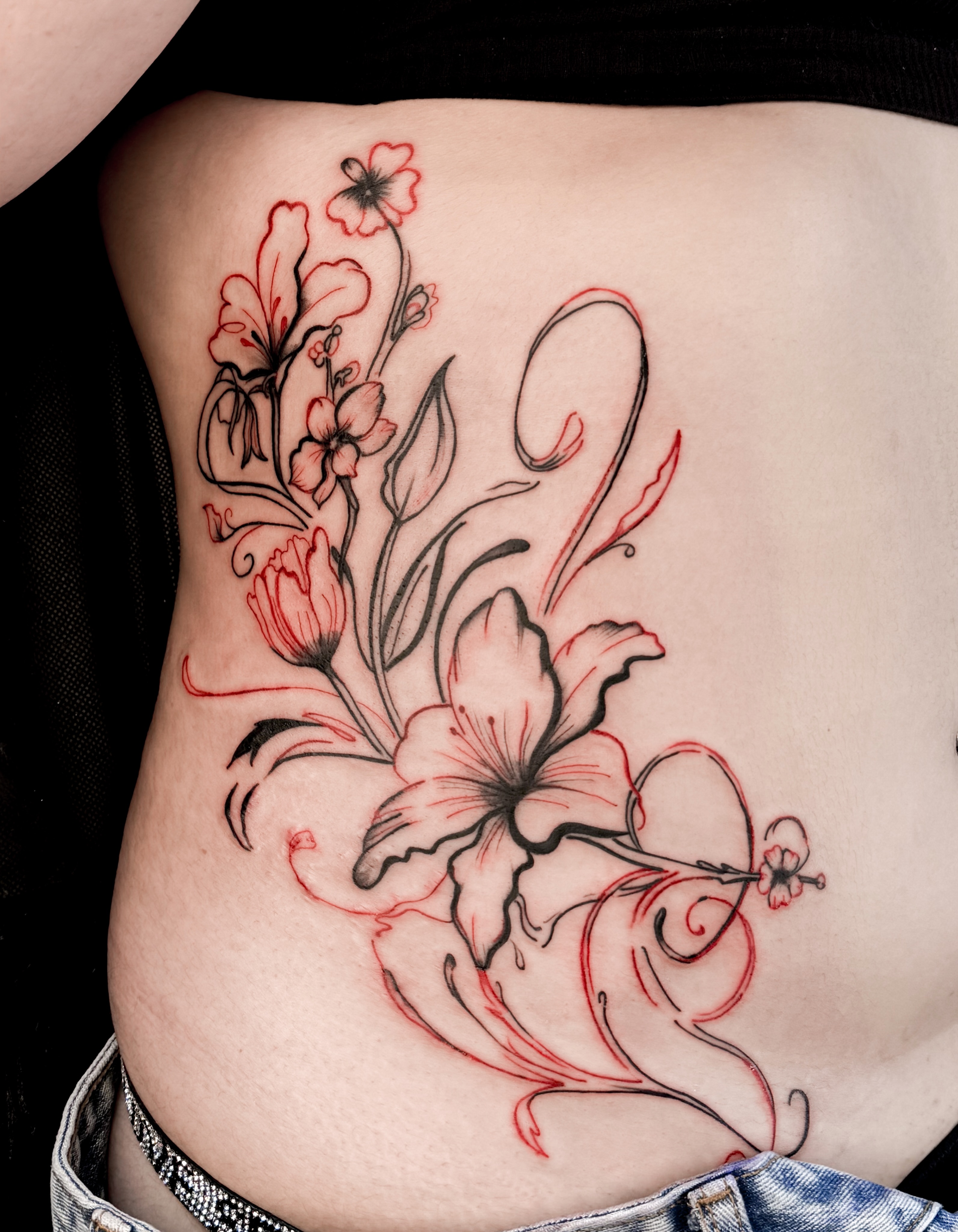 Floral arrangement new school tattoo on the ribs by Tatuajes Denver