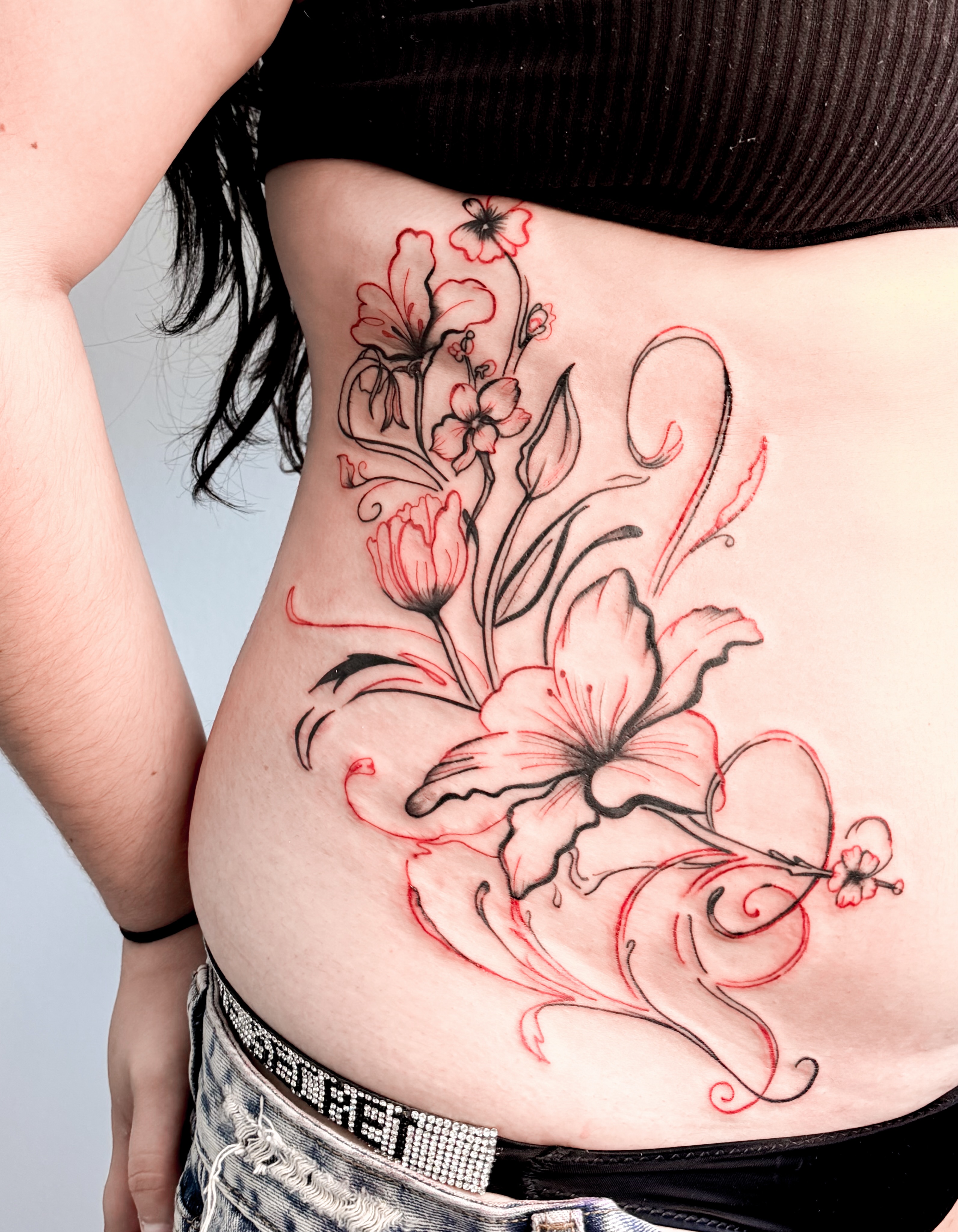 Floral design new school tattoo on the ribs by Tatuajes Denver