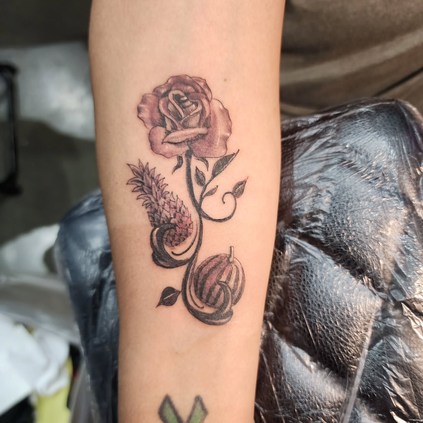 Rose and fruit black and grey tattoo on the forearm by Joe Garcia