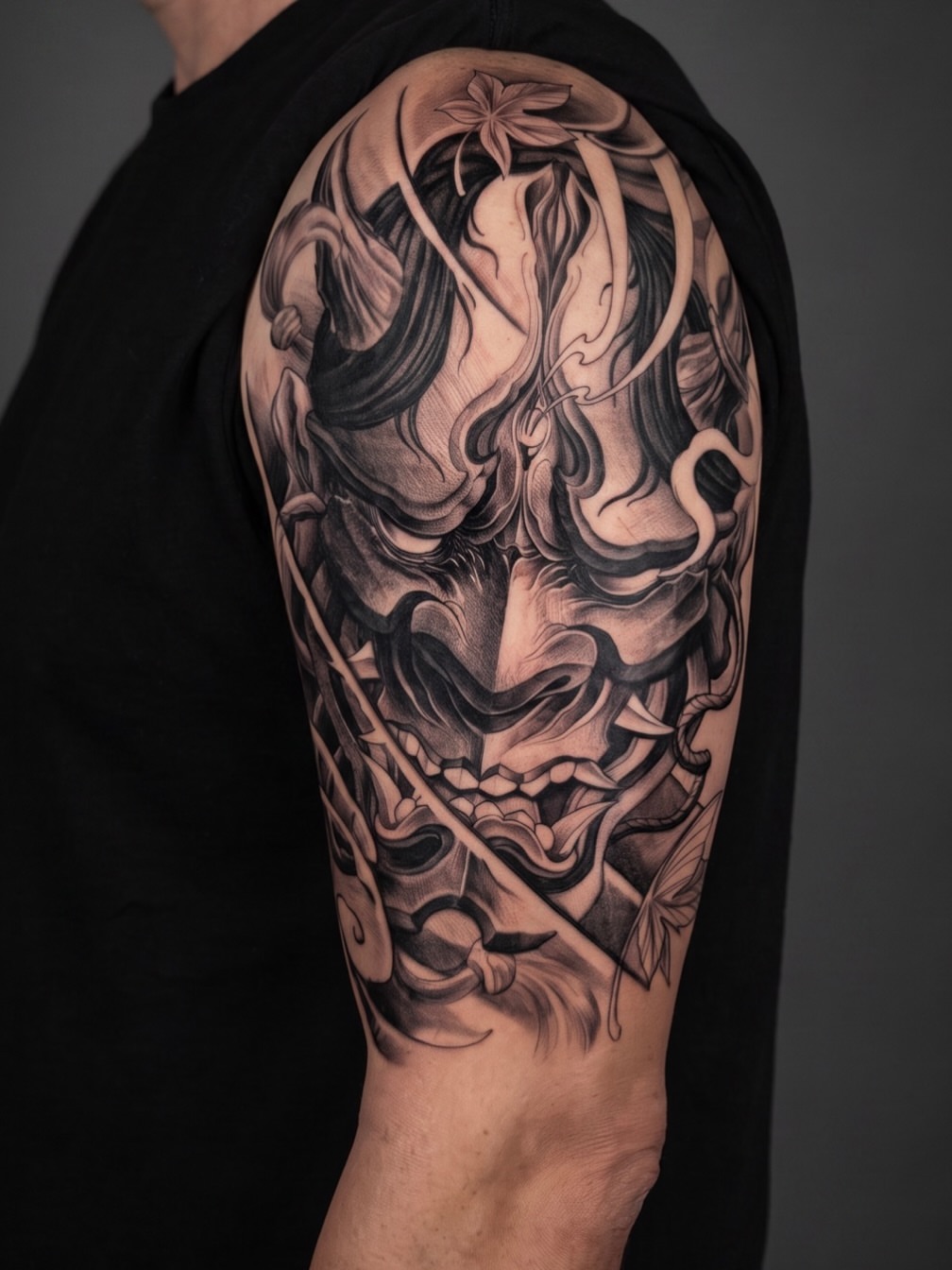 Mask japanese irezumi tattoo on the upper arm by Mike Nance