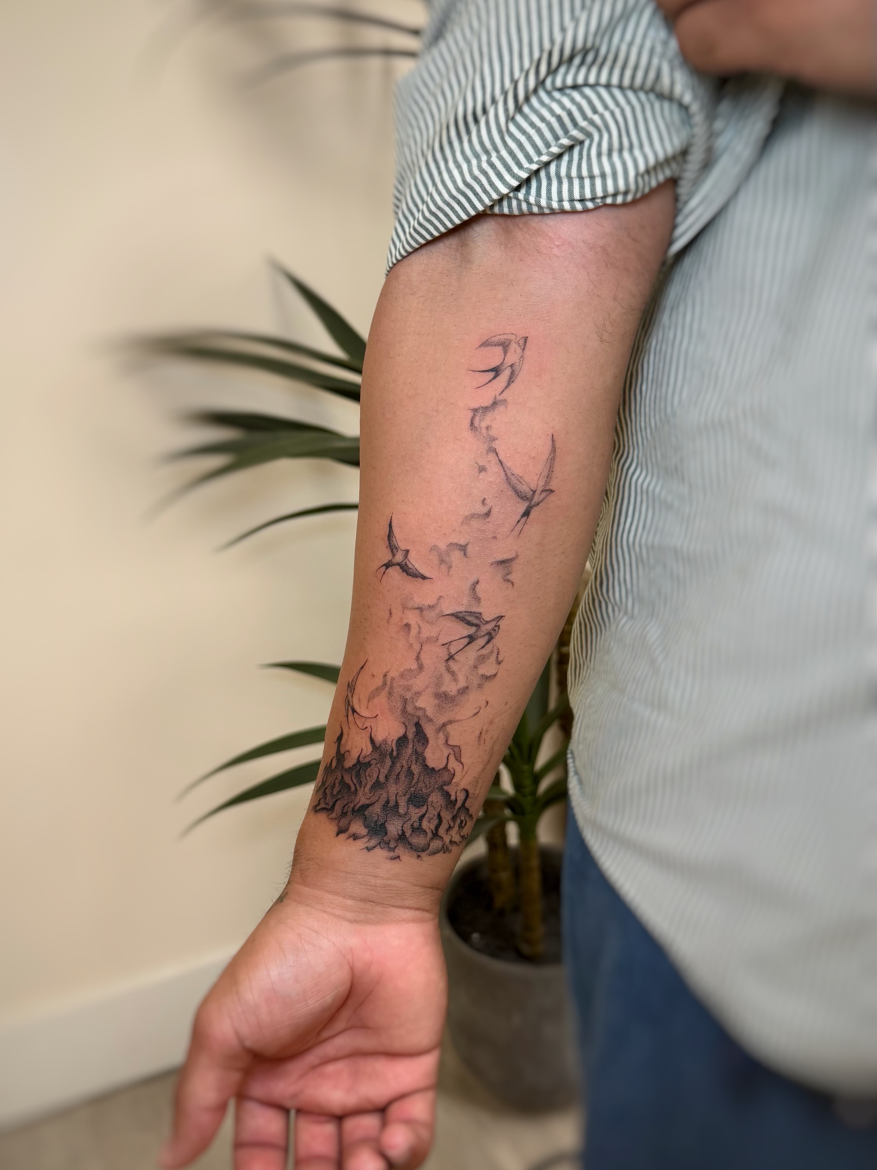 Birds flying through smoke black and grey tattoo on the forearm by David