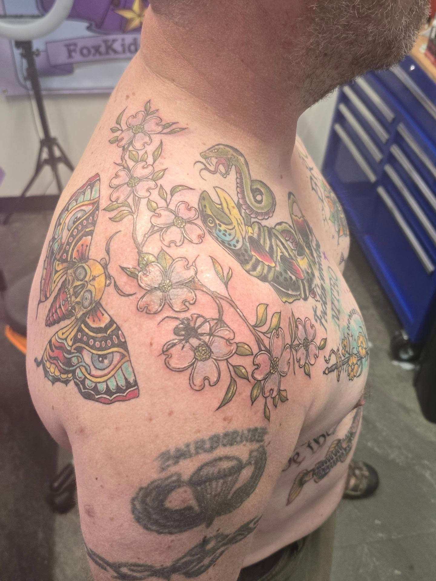 Snake and flowers American traditional tattoo on the shoulder by Val Sanchez