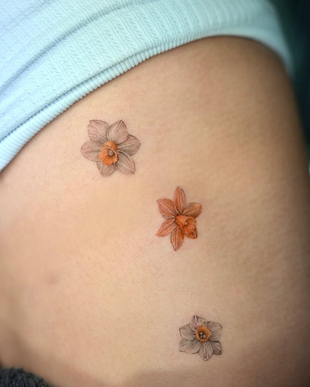 Daffodils realism tattoo on the thigh by ⟡ 𝙶𝙰𝙾𝙽 ⟡ 제주타투 가온 Jejutattoo