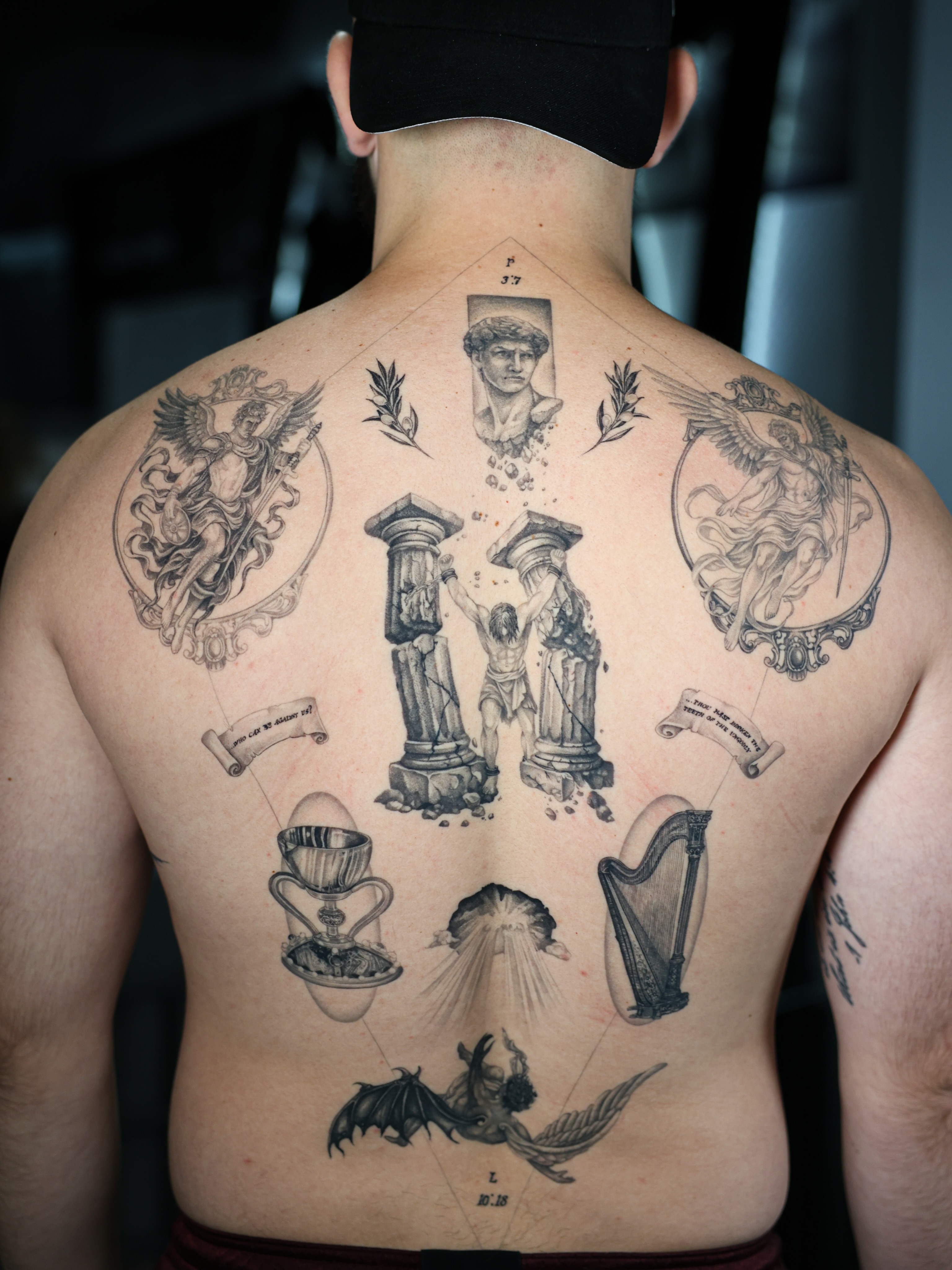 Religious iconography black and grey tattoo on the back by Tiny