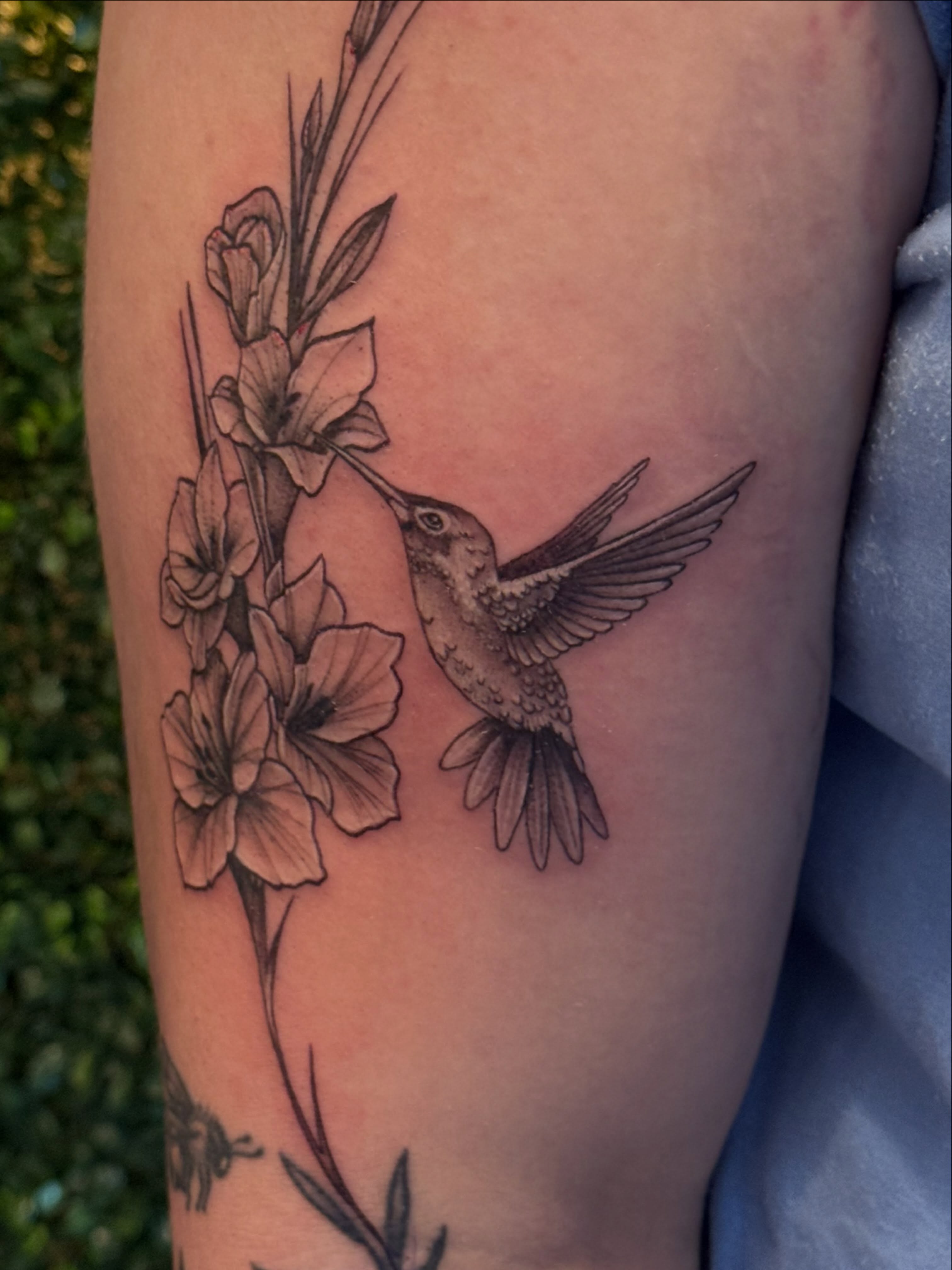 Hummingbird and flowers realism tattoo on the forearm by Lauren Horness