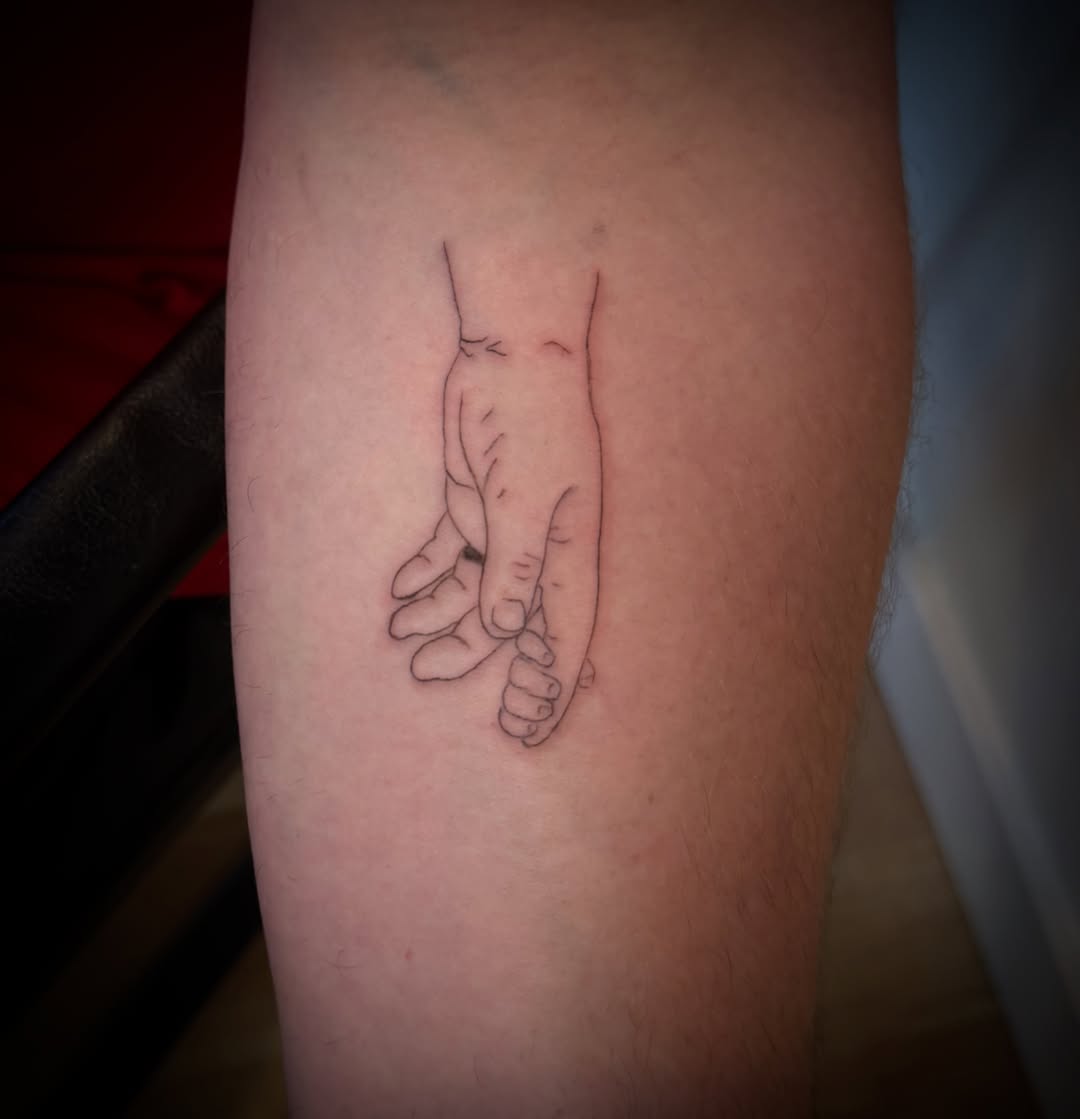 Holding hands black and grey tattoo on the forearm by TolzinInk, Brookings, South Dakota