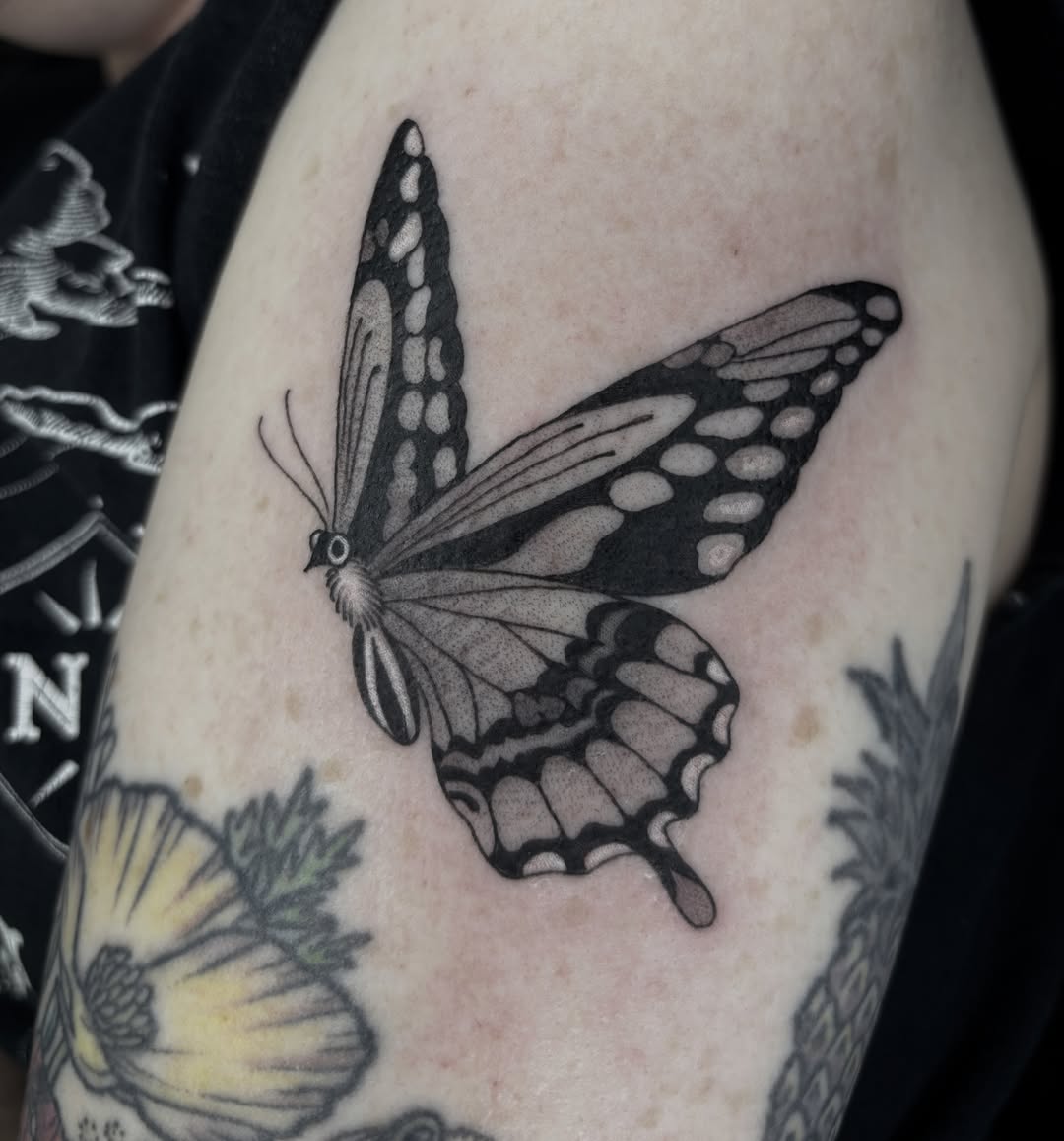 Butterfly black and grey tattoo on the upper arm by Amelia Rose, Los Angeles, California