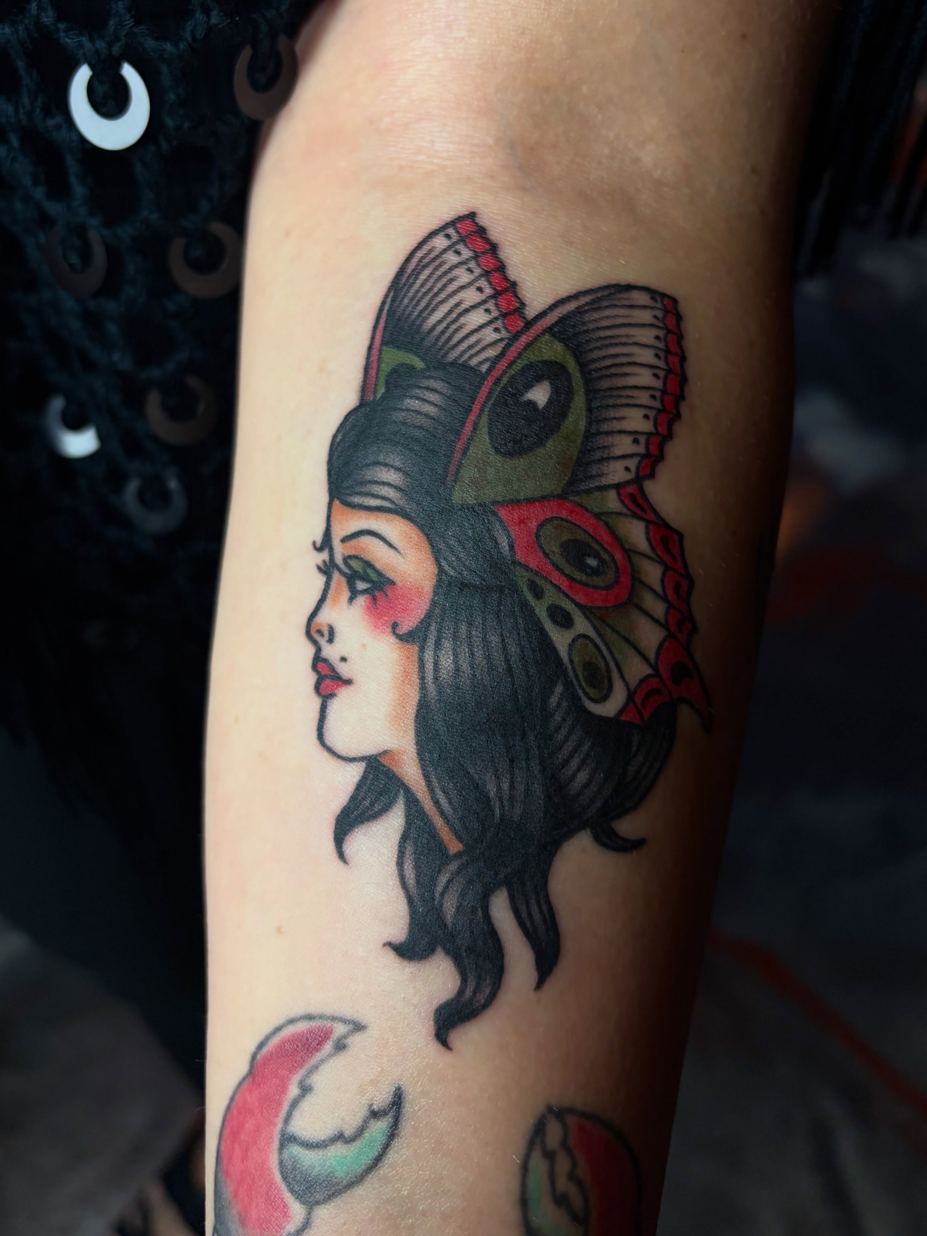 Woman with butterfly American traditional tattoo on the forearm by destany aguilera, Davenport, Iowa