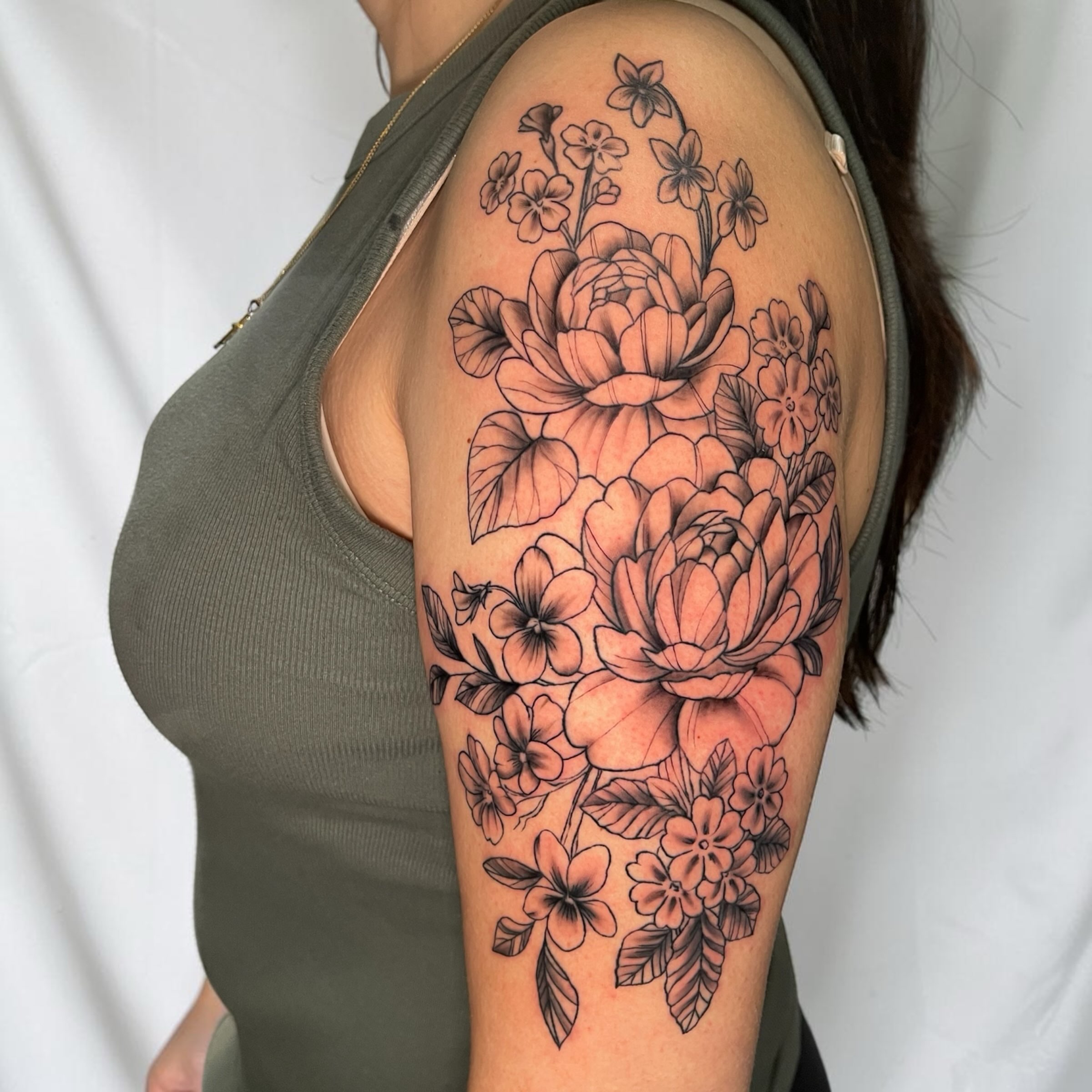 Floral bouquet black and grey tattoo on the upper arm by Brooke Kresco
