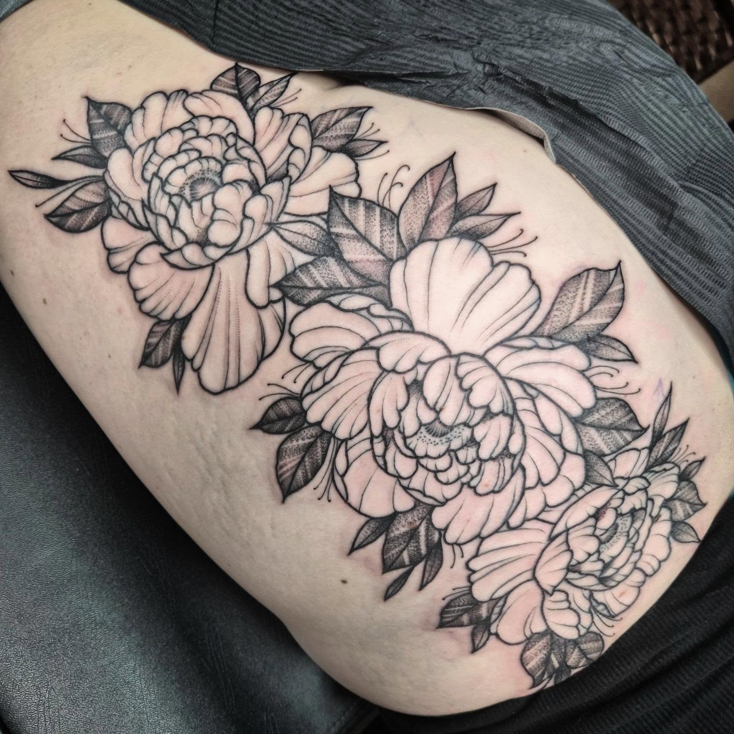 Peony flowers black and grey tattoo on the thigh by Taylor Popkins