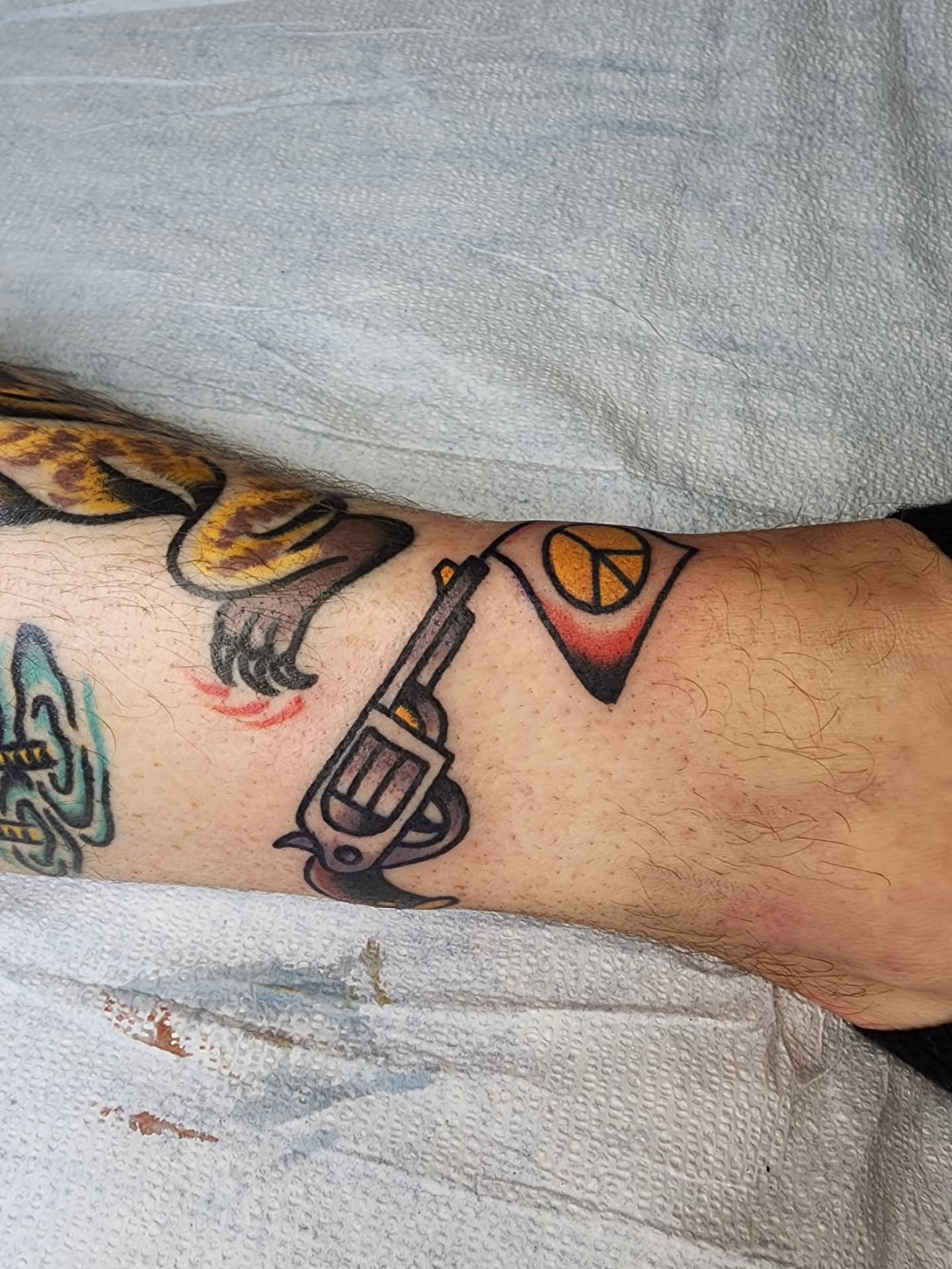 Gun and peace sign American traditional tattoo on the forearm by πππππ