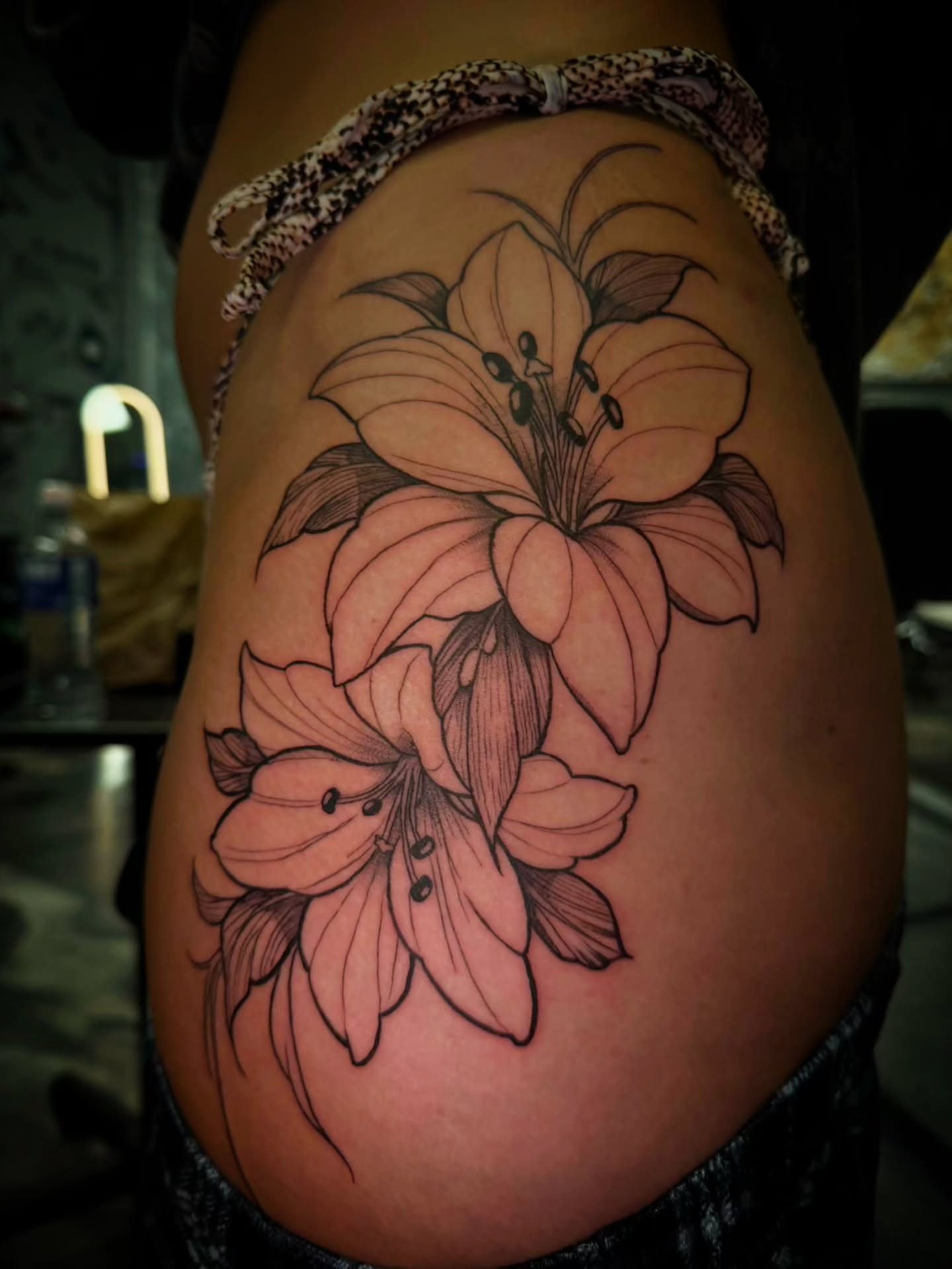 Lilies black and grey tattoo on the thigh by 𝕸 𝖆 𝖓 𝖔 𝖑 𝖔