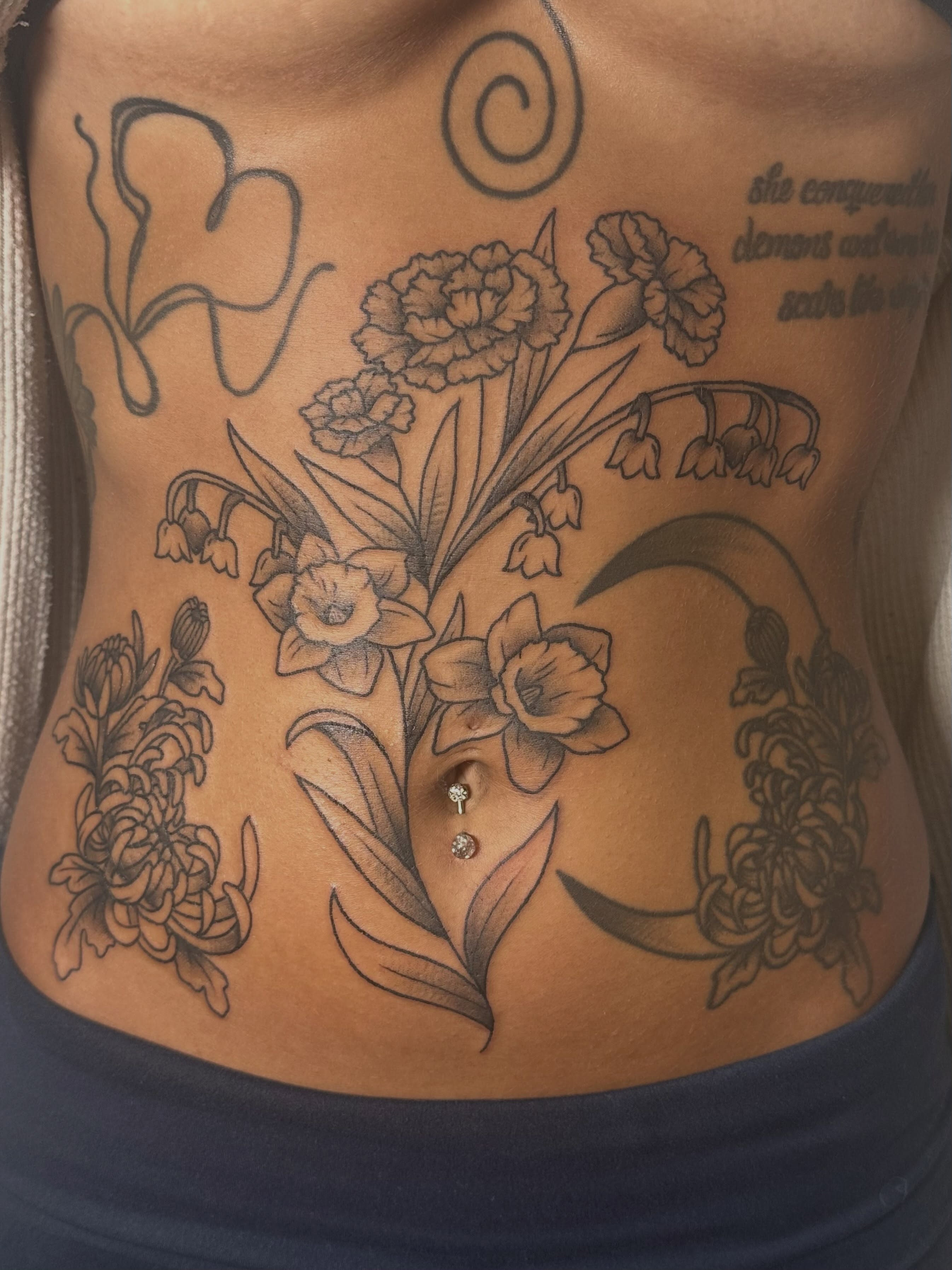 Floral arrangement black and grey tattoo on the ribs by Tattoo artist