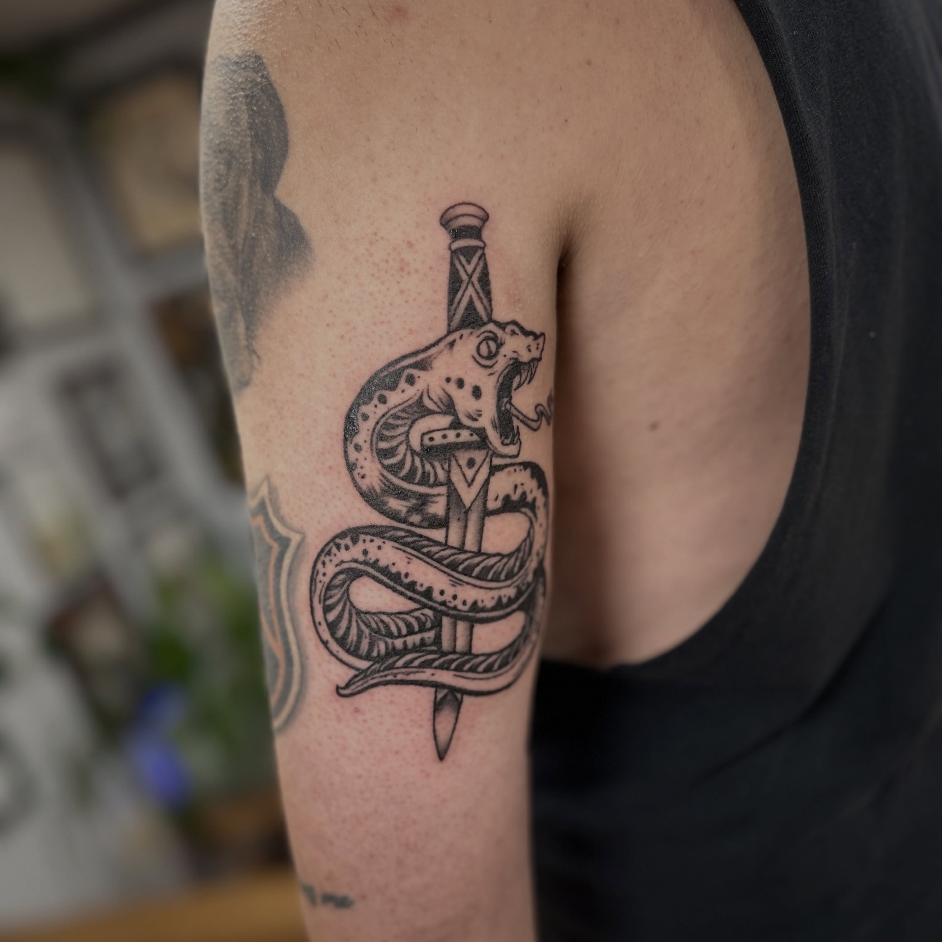 Snake and dagger black and grey tattoo on the upper arm by Austin C Pratt-Fusari