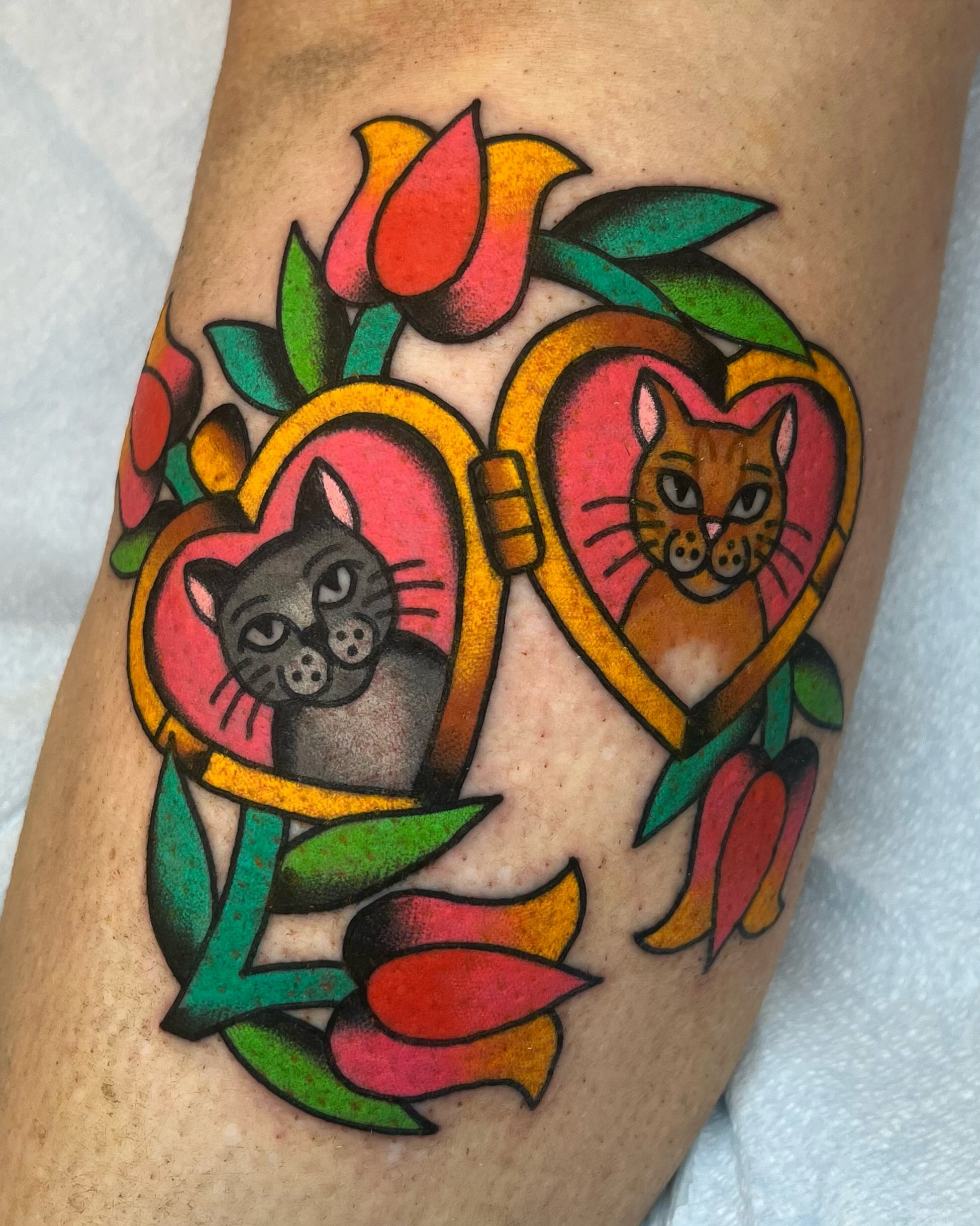 Cats in heart frames American traditional tattoo on the forearm by Em Adkins