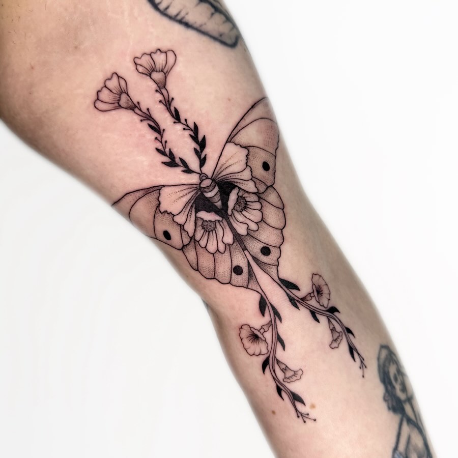 Butterfly and flowers black and grey tattoo on the forearm by Nika