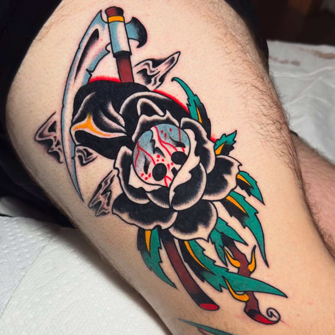 Rose with skull and axe American traditional tattoo on the thigh by 𝐬𝐚𝐬𝐡𝐚 𝐯𝐚𝐧𝐝𝐚𝐥, Nashville, Tennessee