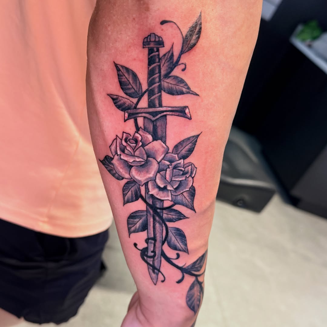 Sword and roses black and grey tattoo on the forearm by Sean Rakos, Austin, Texas