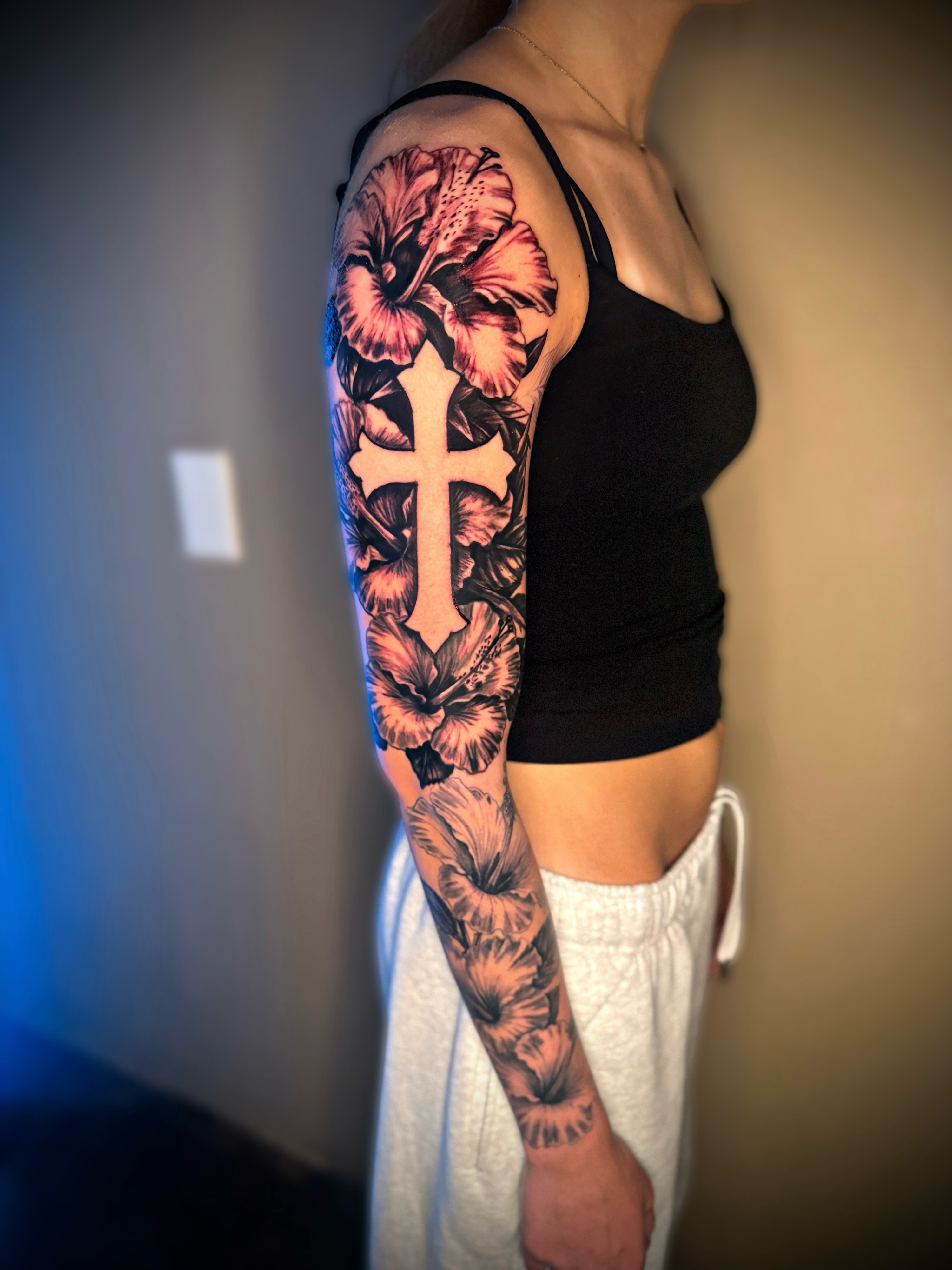 Cross and hibiscus realism tattoo on the upper arm by Dallas Tattoo Artist📍