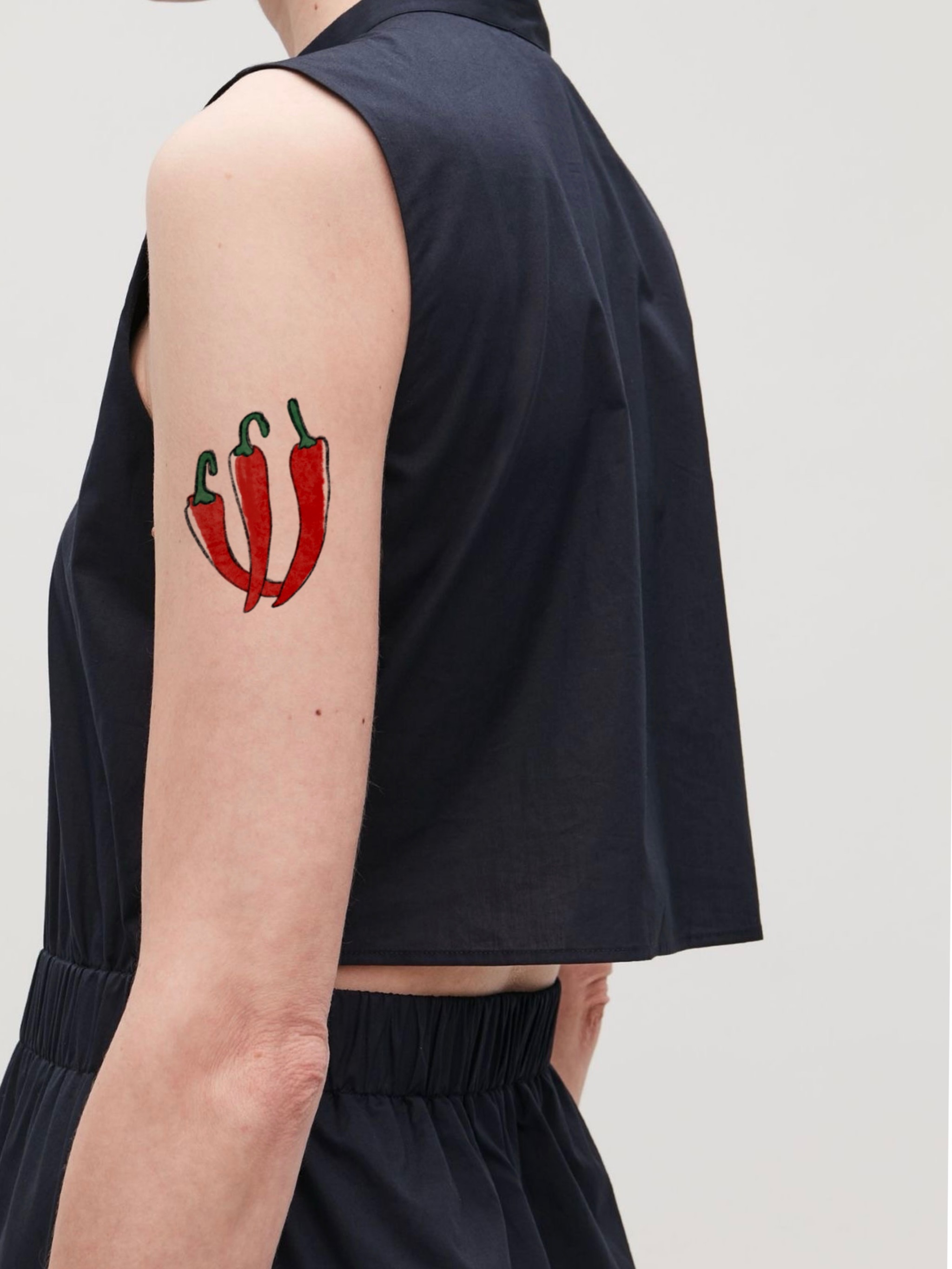 Chili peppers American traditional tattoo on the upper arm by Ink _daisy_