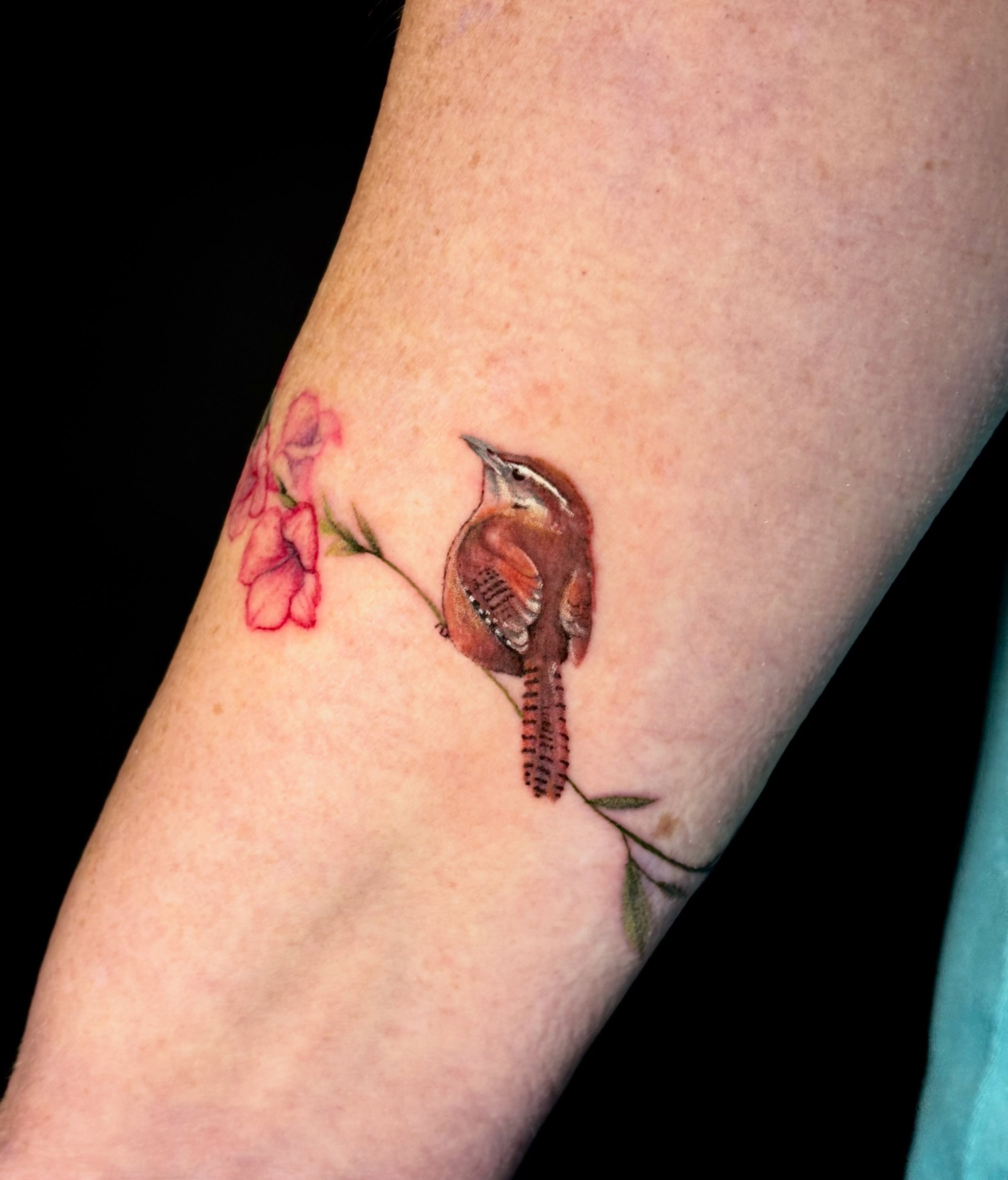 Bird and flowers realism tattoo on the forearm by Sarah Sacco
