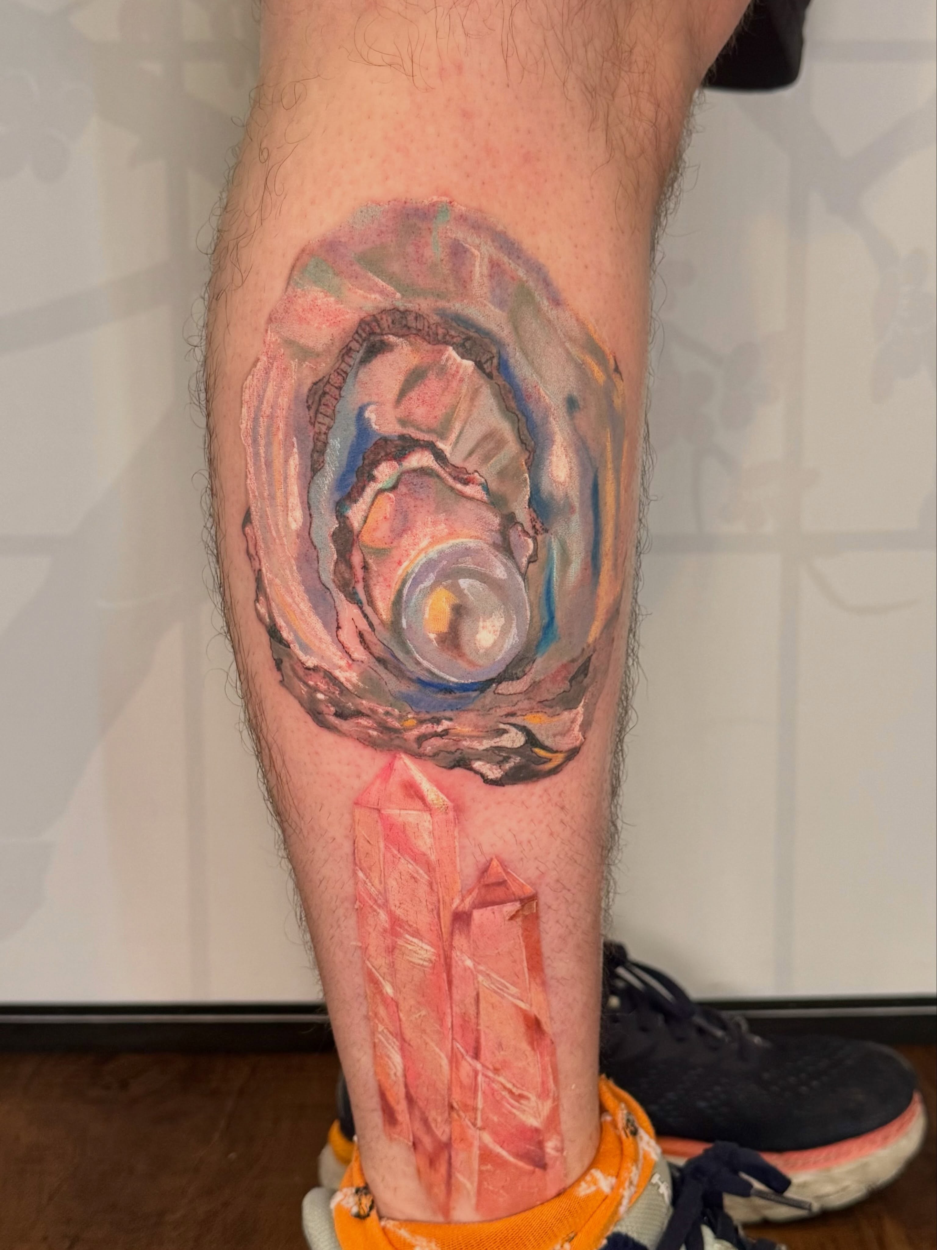 Crystal and abstract swirl watercolor tattoo on the calf by Cohen