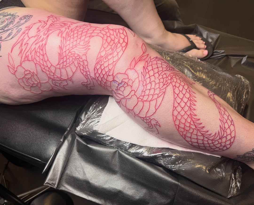 Dragon and flowers American traditional tattoo on the leg by Jerry Thomas